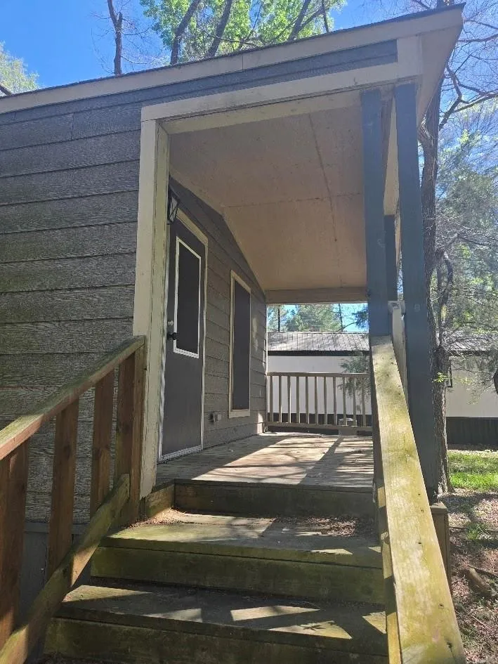 Covered front porch with wood plank flooring and stairs