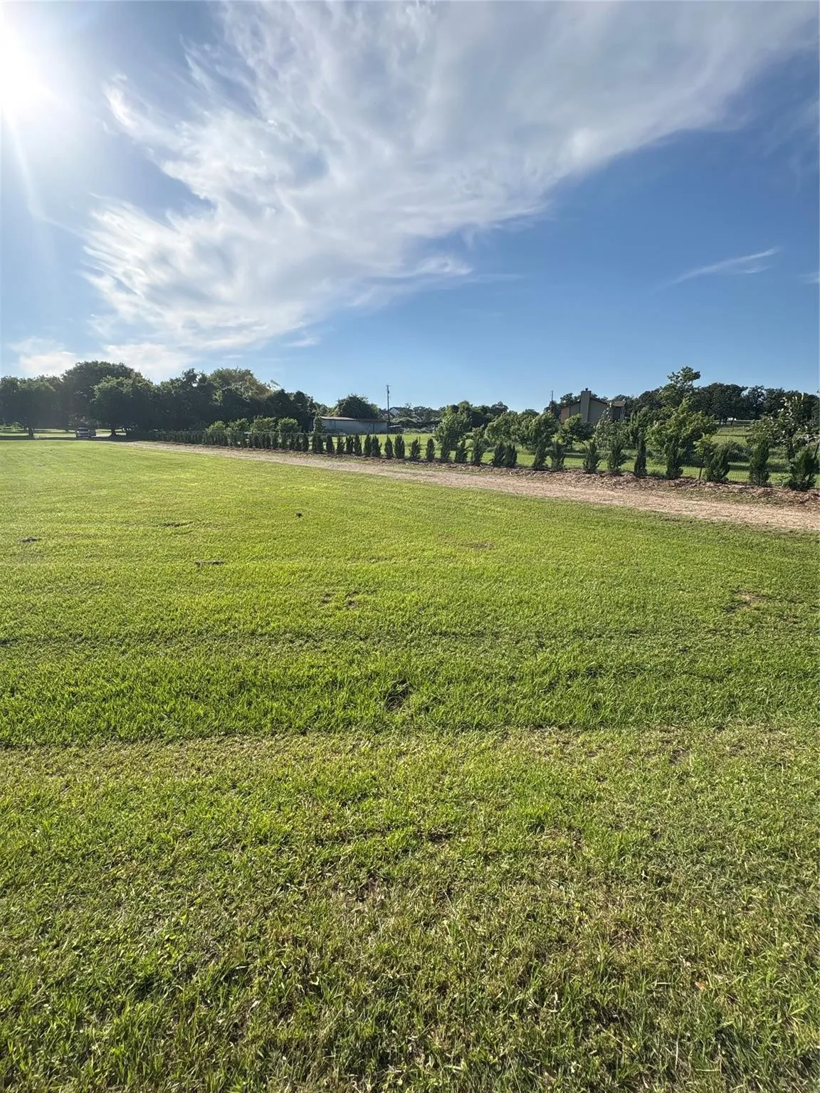 Expansive green lawn with a tree-lined perimeter