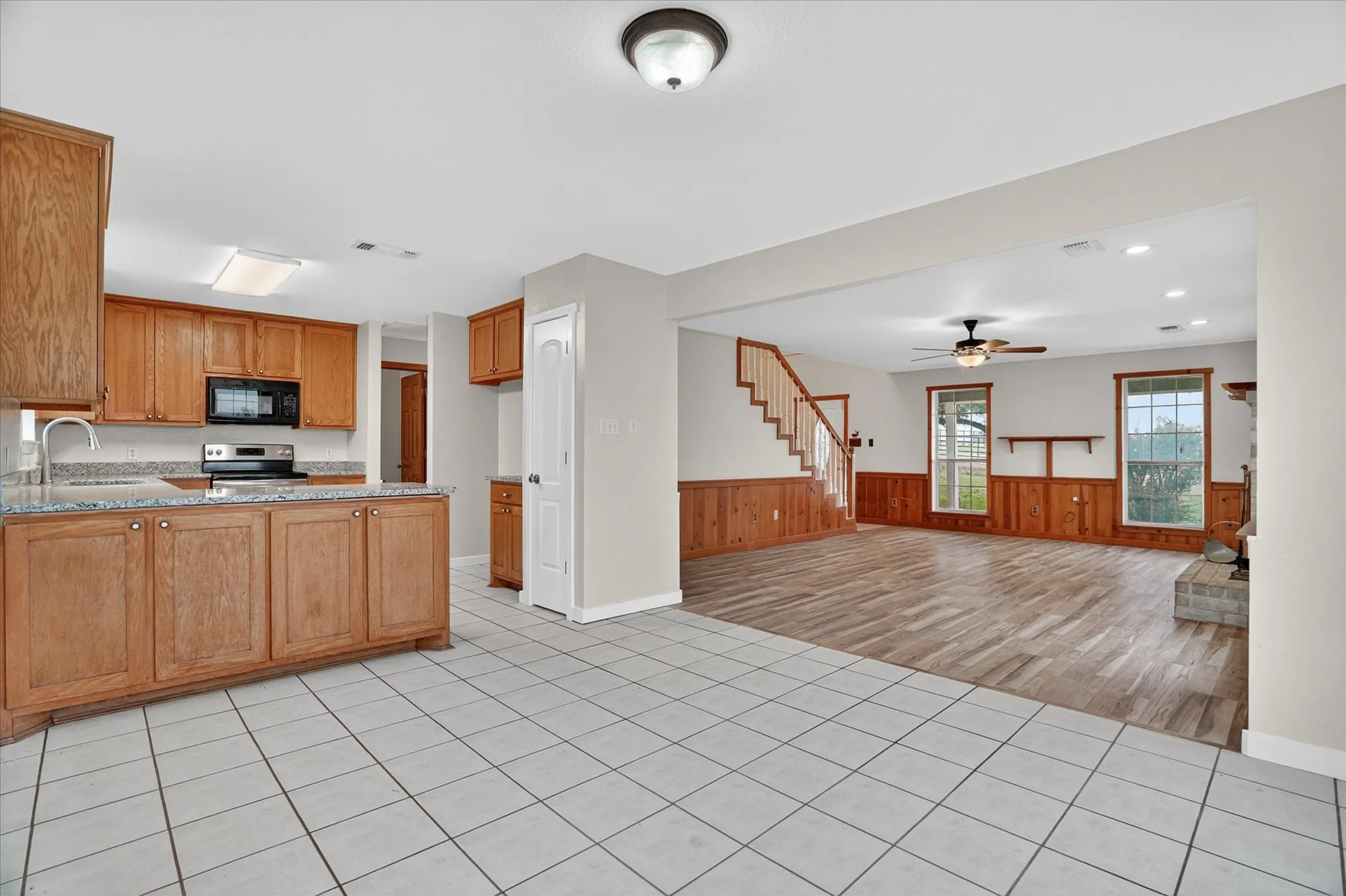 Kitchen featuring tile flooring, wooden cabinetry, and granite-style countertops