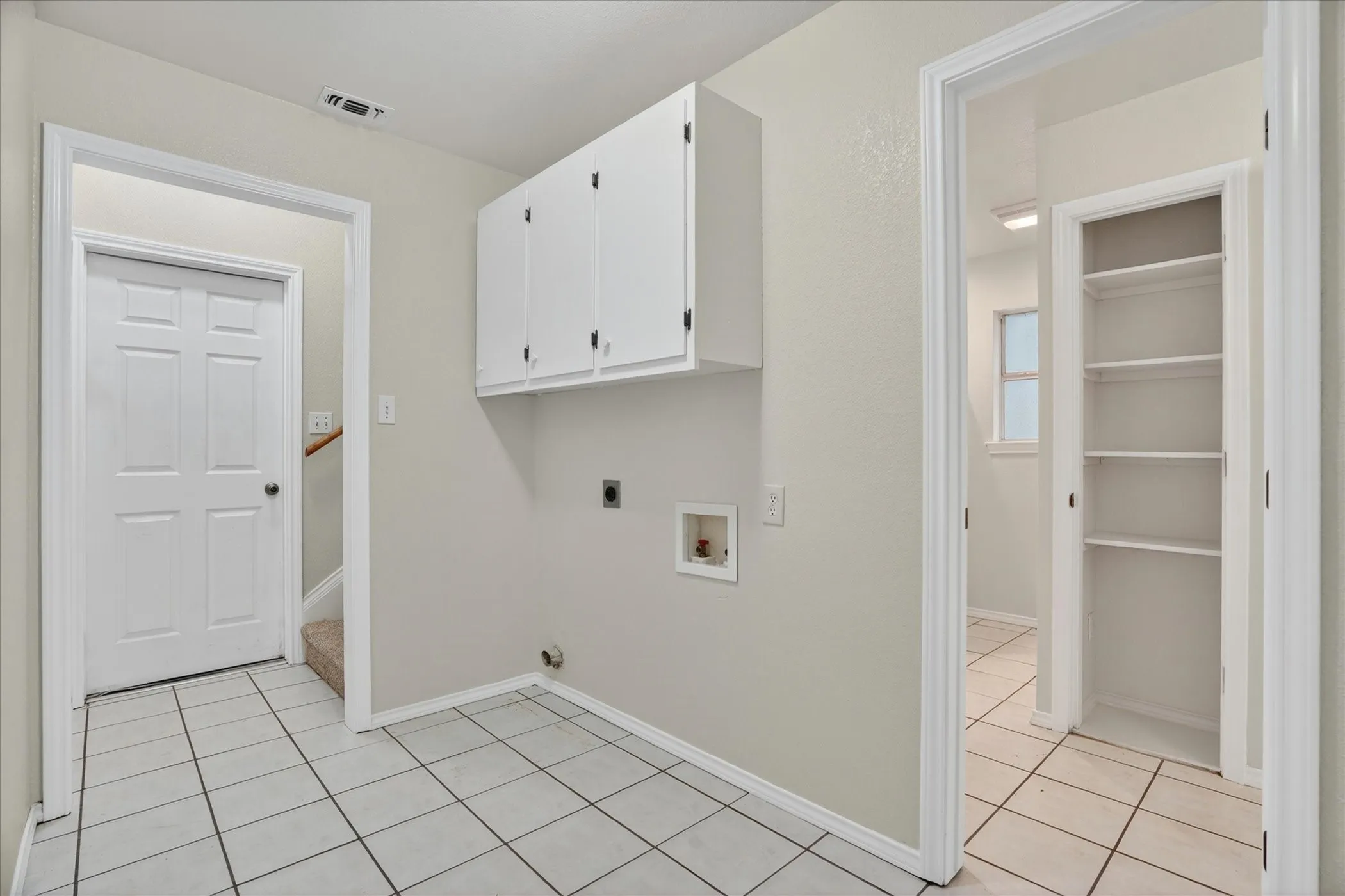 Laundry area featuring white tile flooring