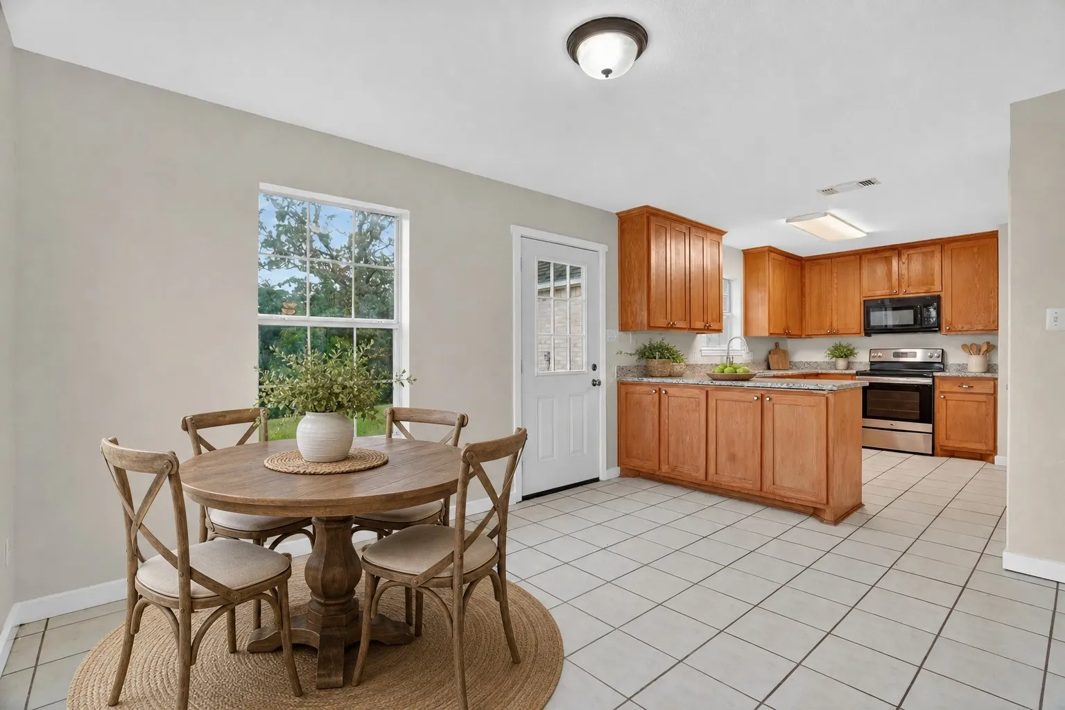Kitchen featuring wood cabinetry, an integrated island, stainless steel appliances, and tile flooring