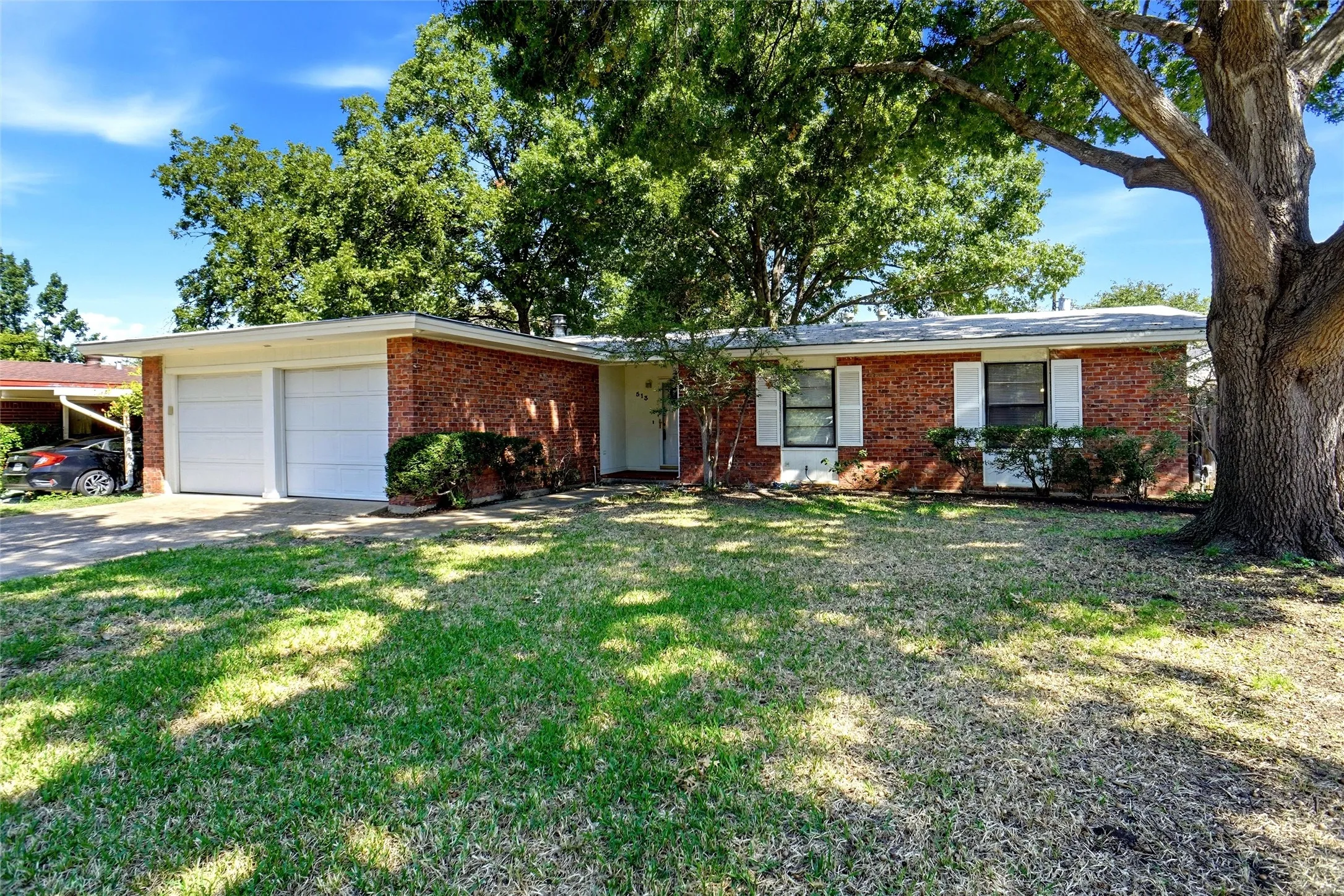 Lovely Brick Home with manicured Lawn, shaded by mature Oak Trees