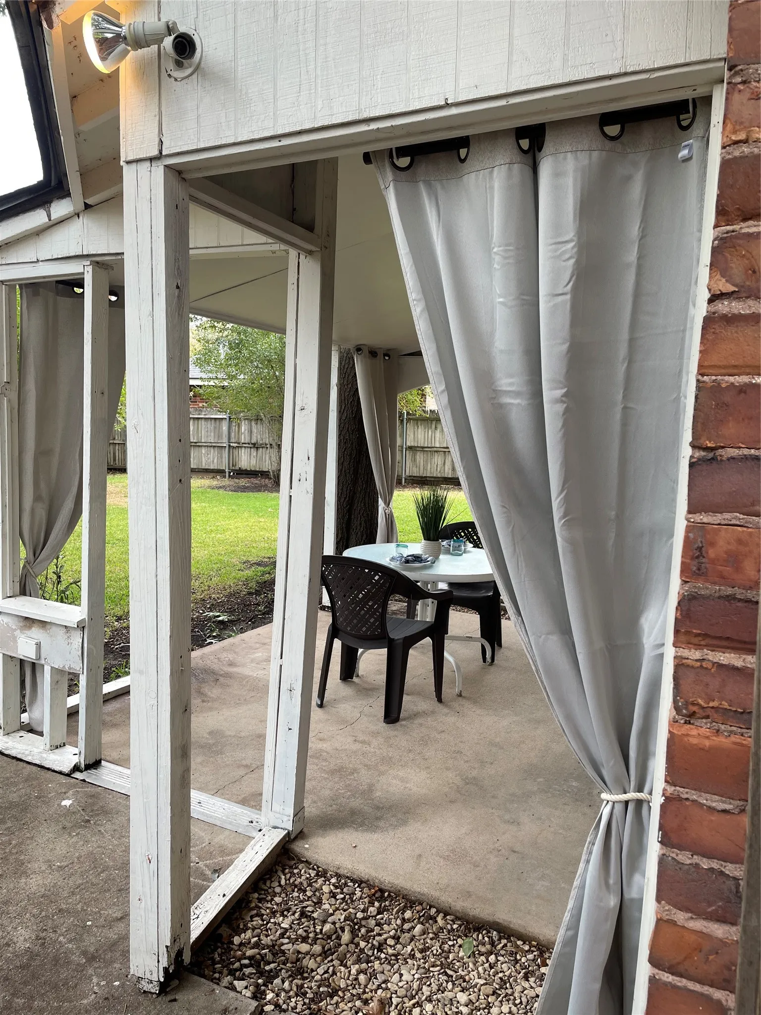 Side view of back patio.
Cozy outdoor Curtains with designer pull backs complete this space!