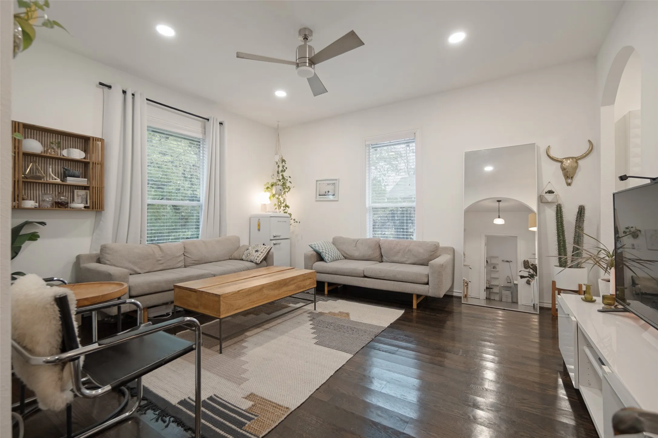 Recessed lighting, wood-finish flooring, ceiling fan, multiple windows with blinds, arched doorway