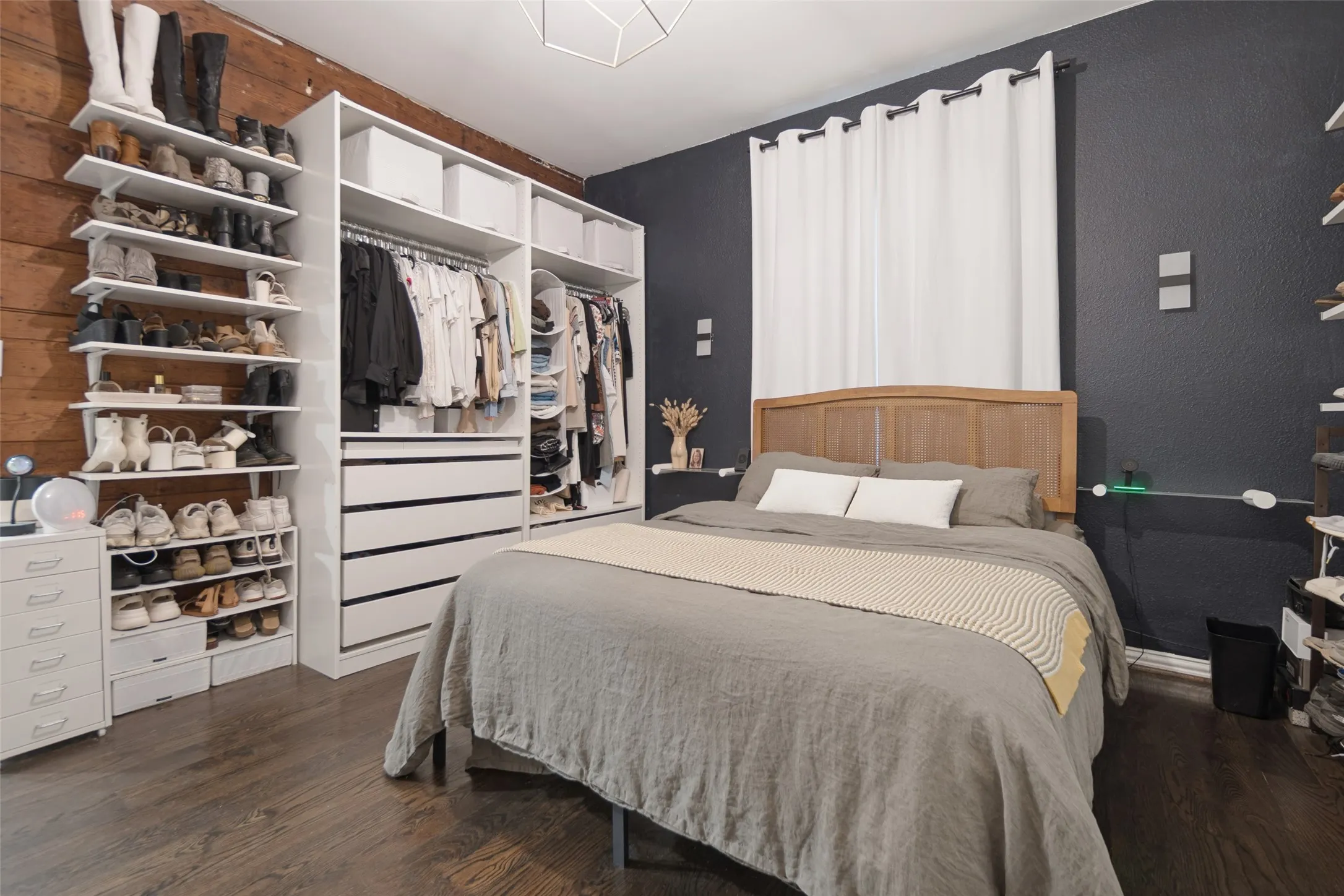 Dark-toned walls, wood-finish flooring, and a built-in closet system