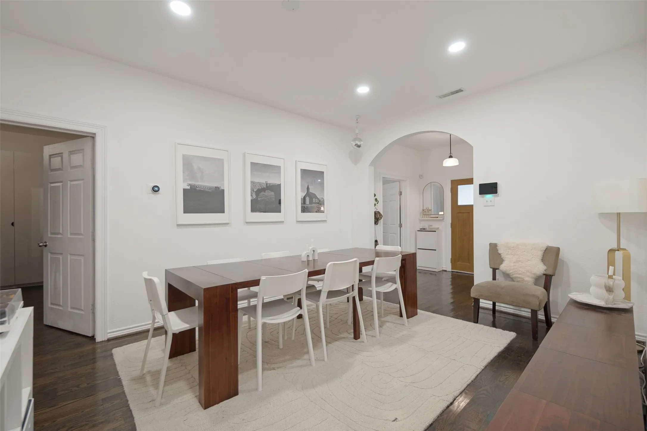 Hardwood flooring, recessed lighting, white walls, and an arched doorway