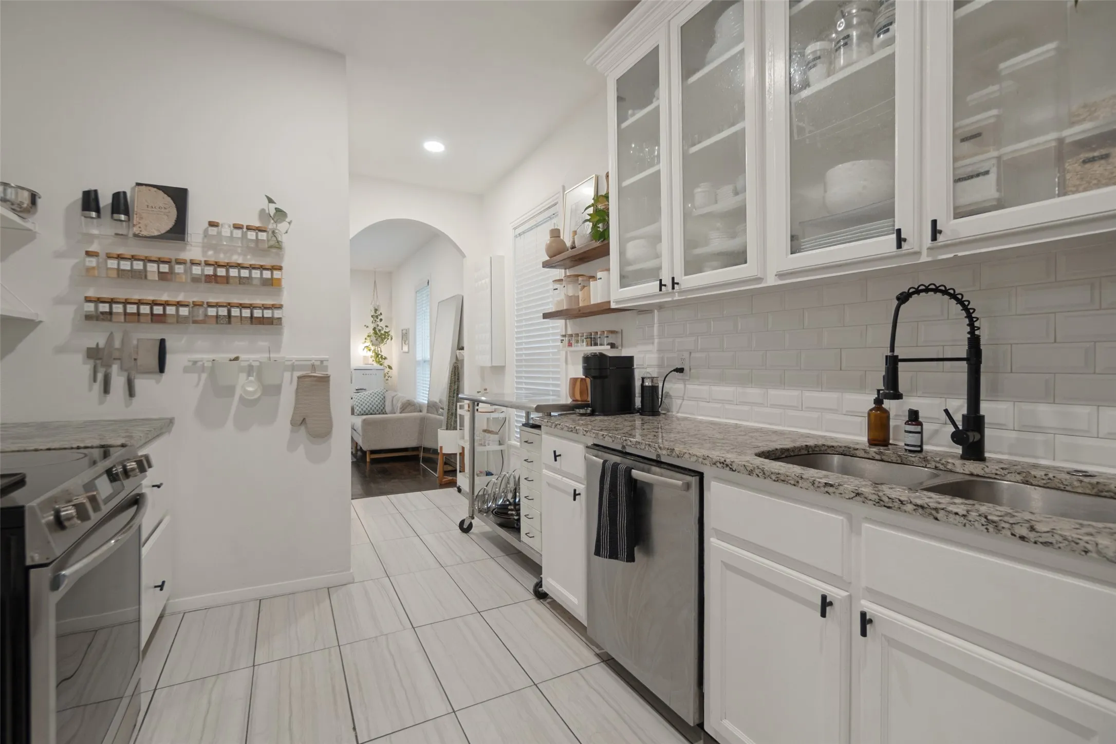 White shaker cabinetry, stainless steel appliances, dual basin sink, subway tile backsplash, and granite countertops