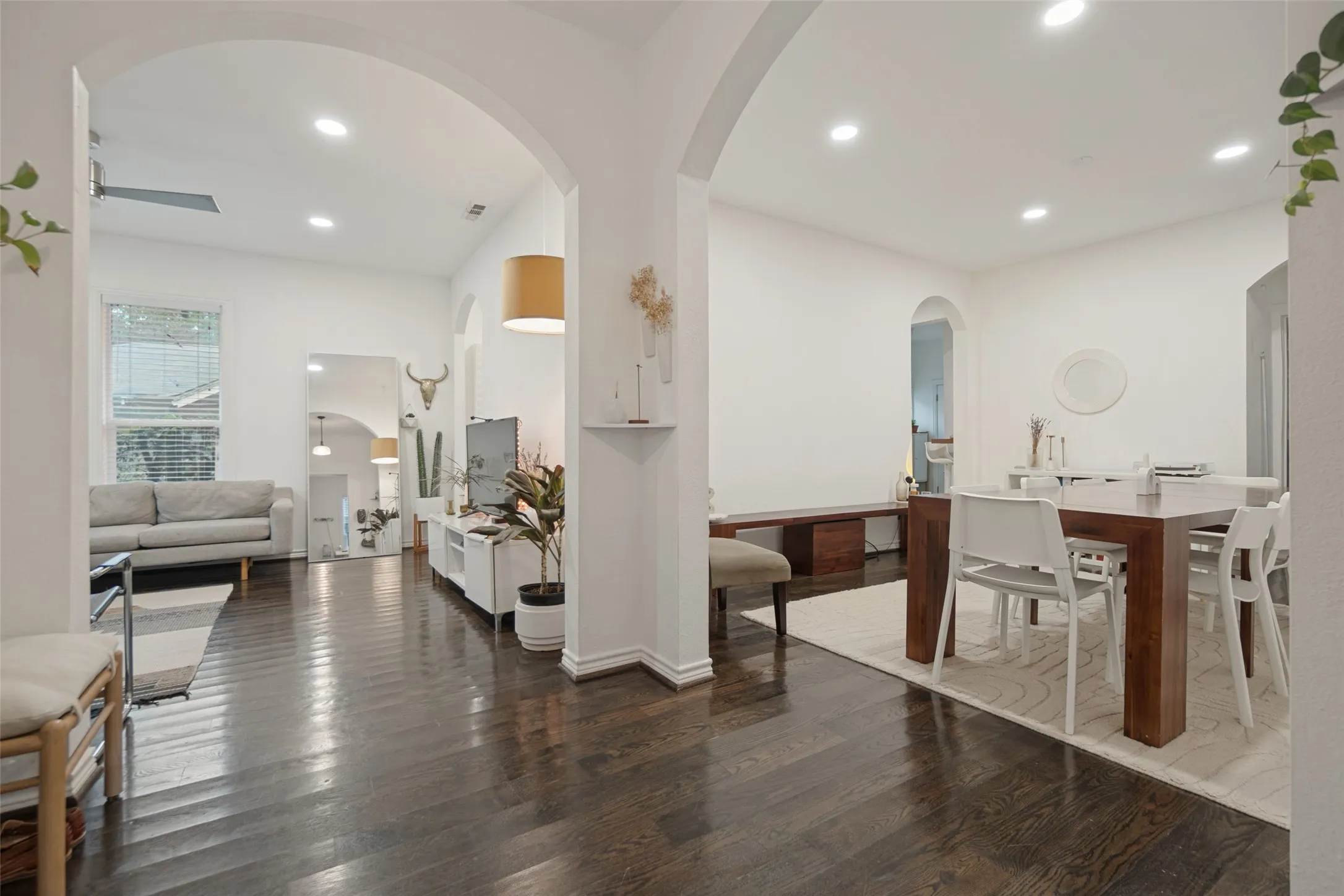 Expansive interior featuring dark wood-finish flooring, recessed ceiling lighting, and archway entries