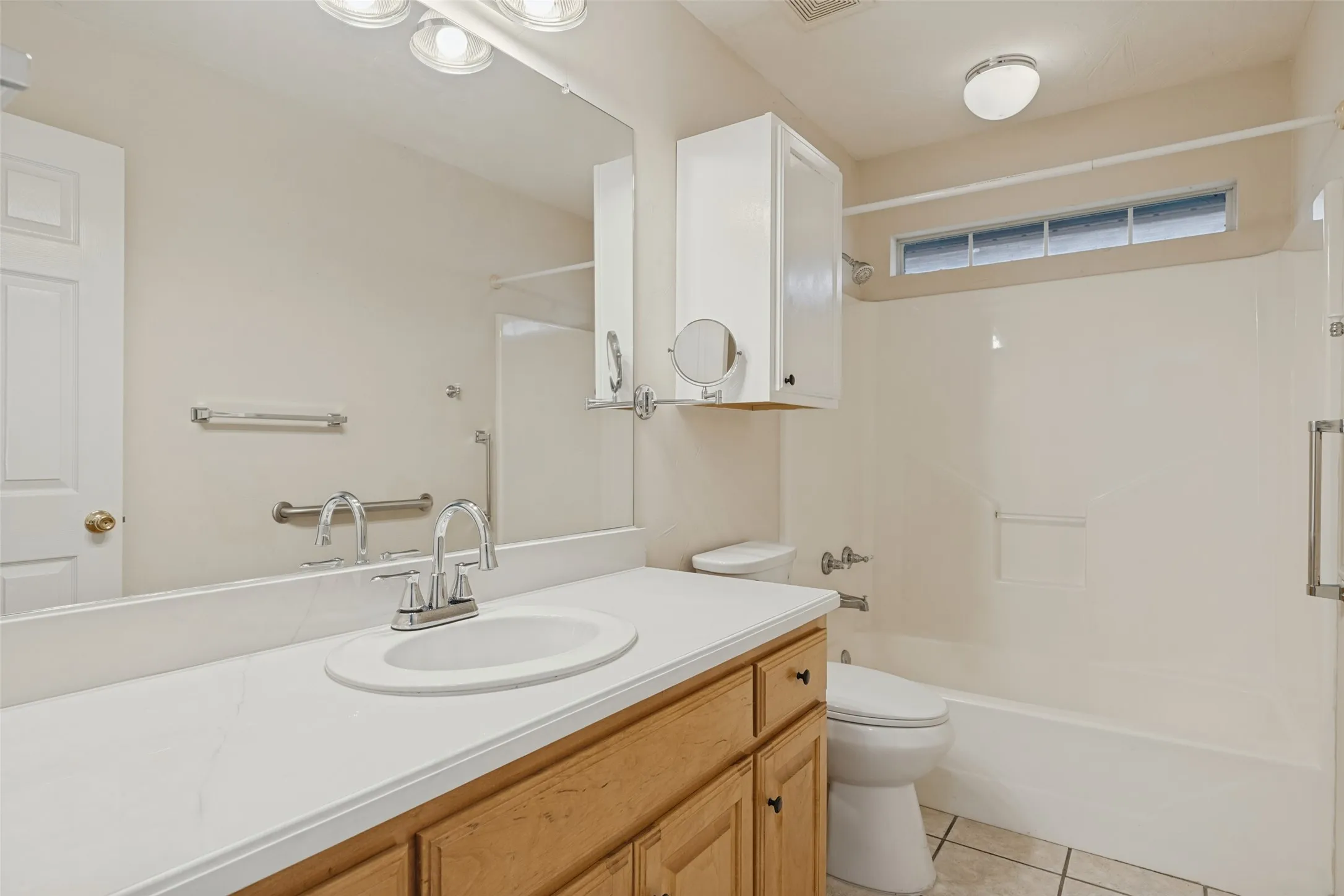 Wood-finish vanity with a white countertop and integrated sink