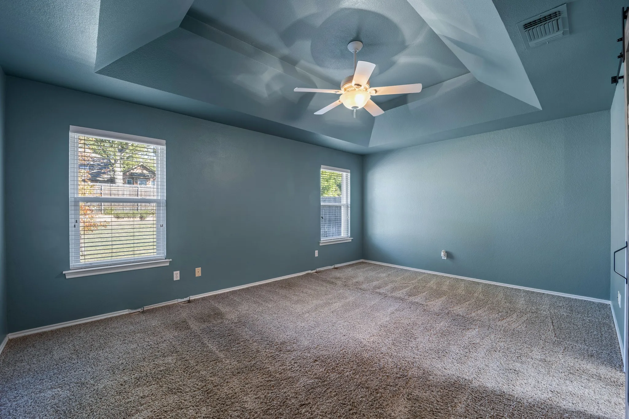 Primary bedroom with backyard views.