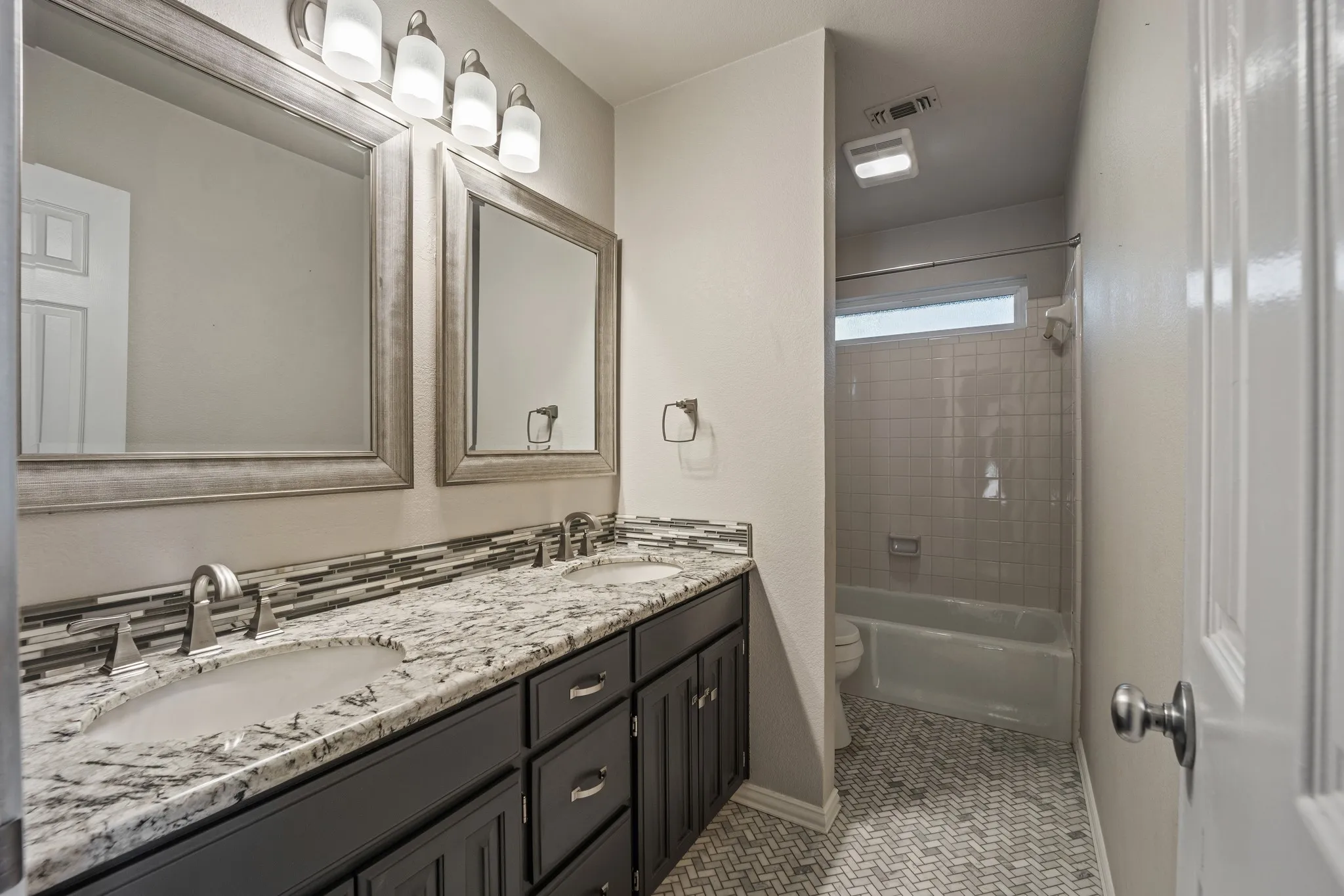 Hall bathroom with dual sinks.