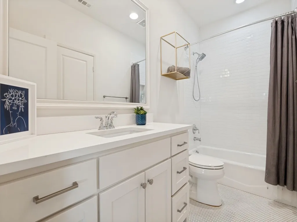 White vanity with an integrated sink, polished chrome faucet, and a quartz-finish countertop