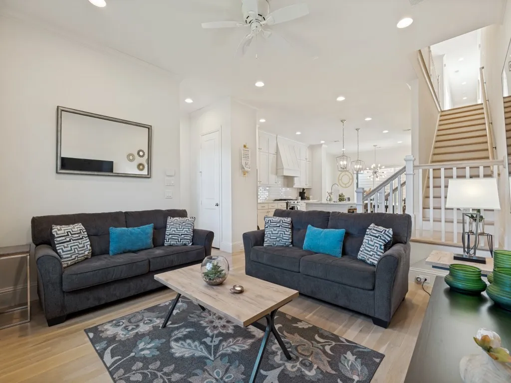 Open-concept living space with light wood-finish flooring, recessed lighting, and a ceiling fan