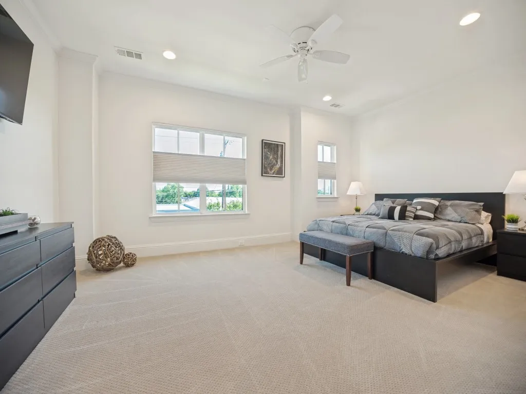 Carpeted room featuring recessed lighting, a ceiling fan, crown molding, and multiple windows with blinds