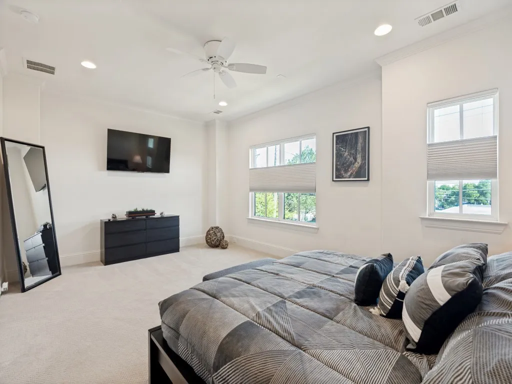 Light-filled interior featuring high ceilings, recessed lighting, and wall-mounted television