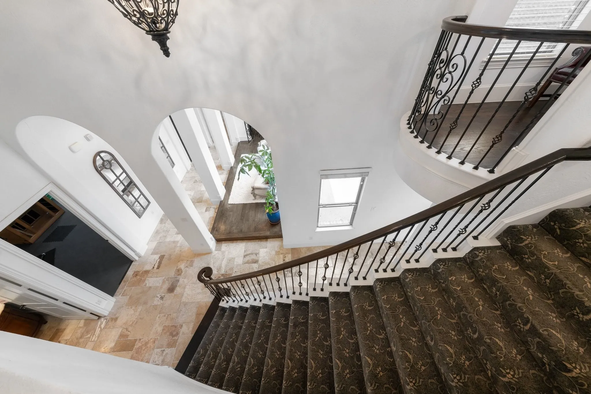 Grand staircase with iron balusters and juliet balcony.