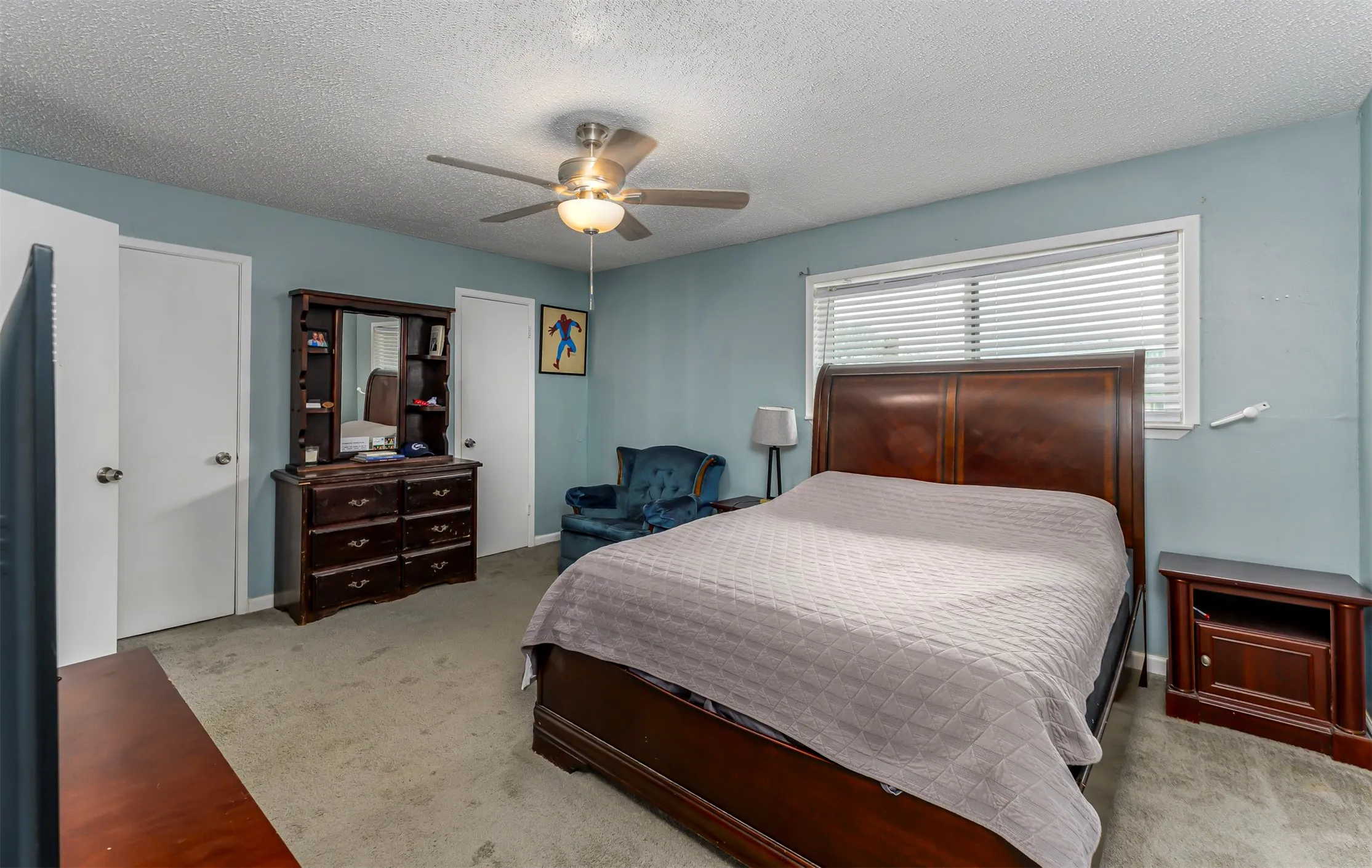 Recessed window with horizontal blinds, overhead ceiling fan with lighting, and two white panel doors