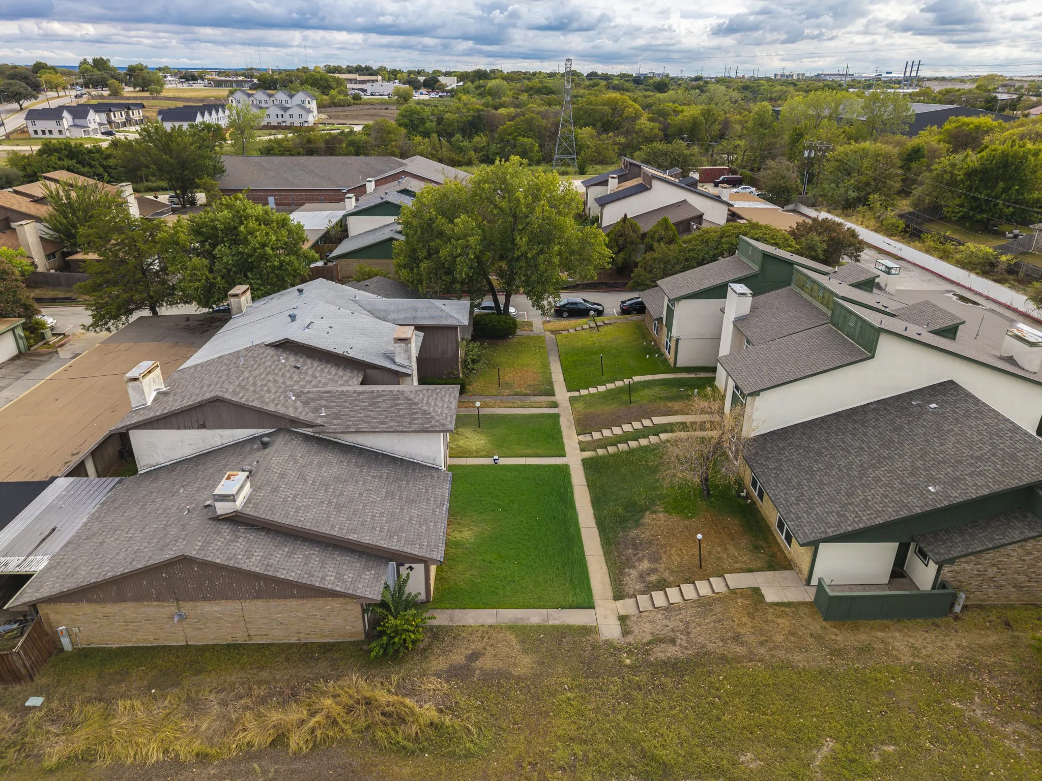 Multiple residential structures featuring pitched composition shingle roofs and brick facades