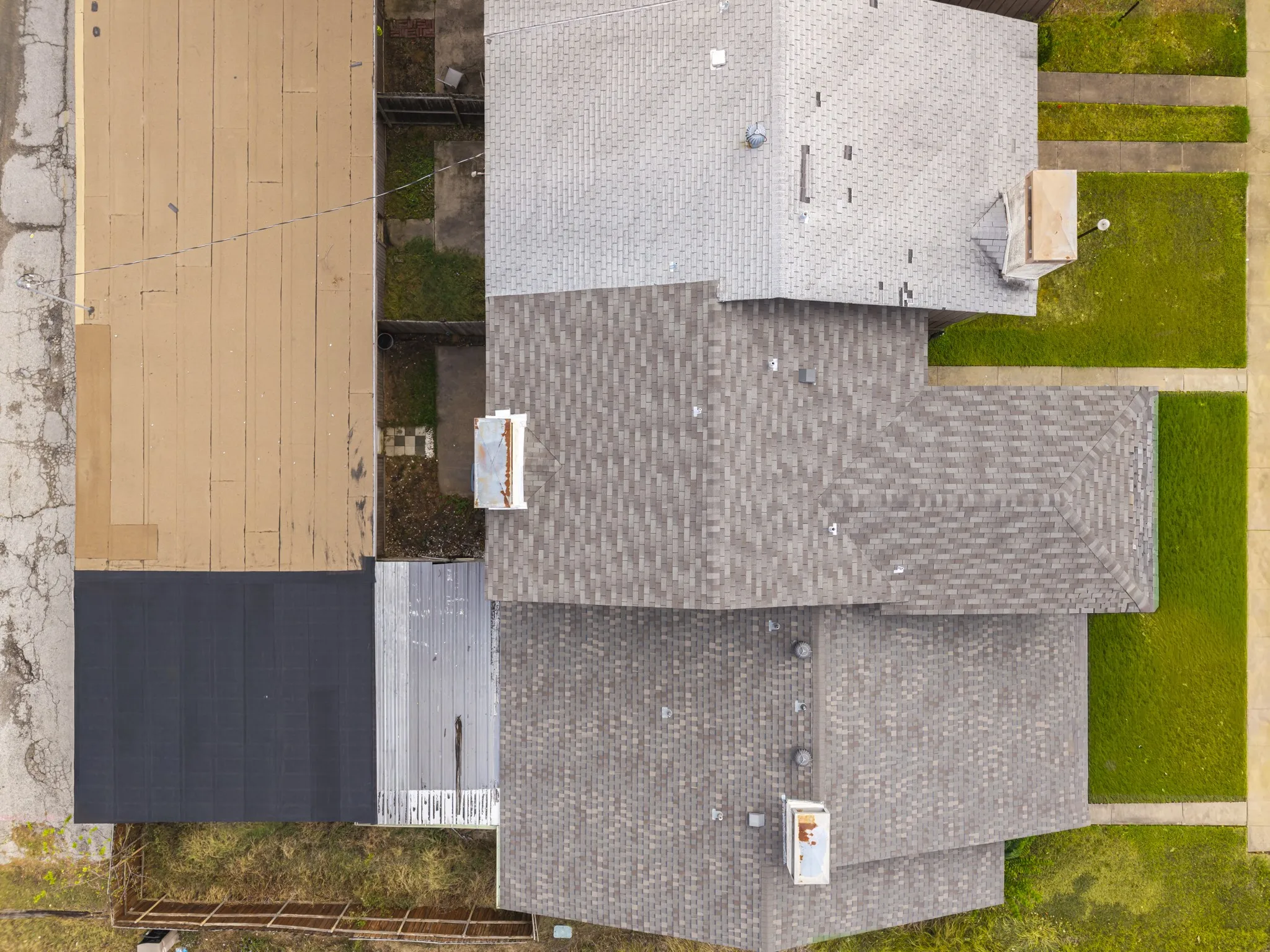Multiple roof lines with varying gray shingle patterns