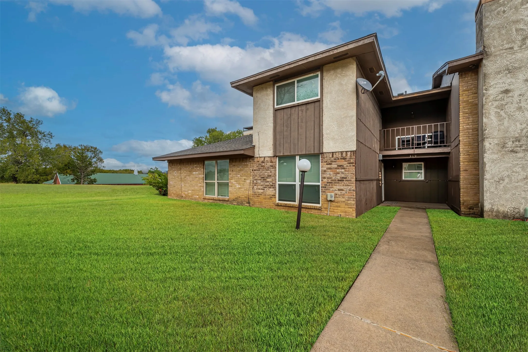 Brick and stucco exterior with dark wood-finish siding accents