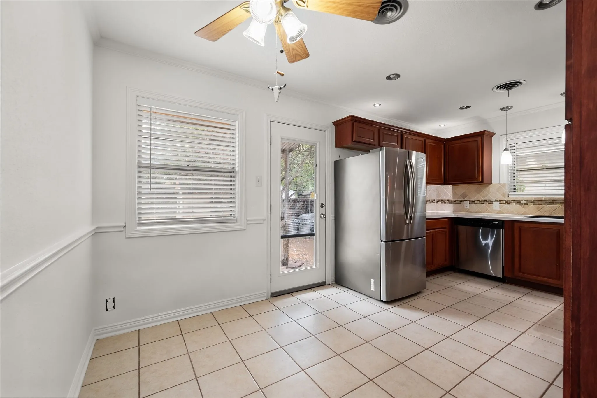 Kitchen featuring wood cabinets, stainless steel appliances, tile flooring, and recessed lighting