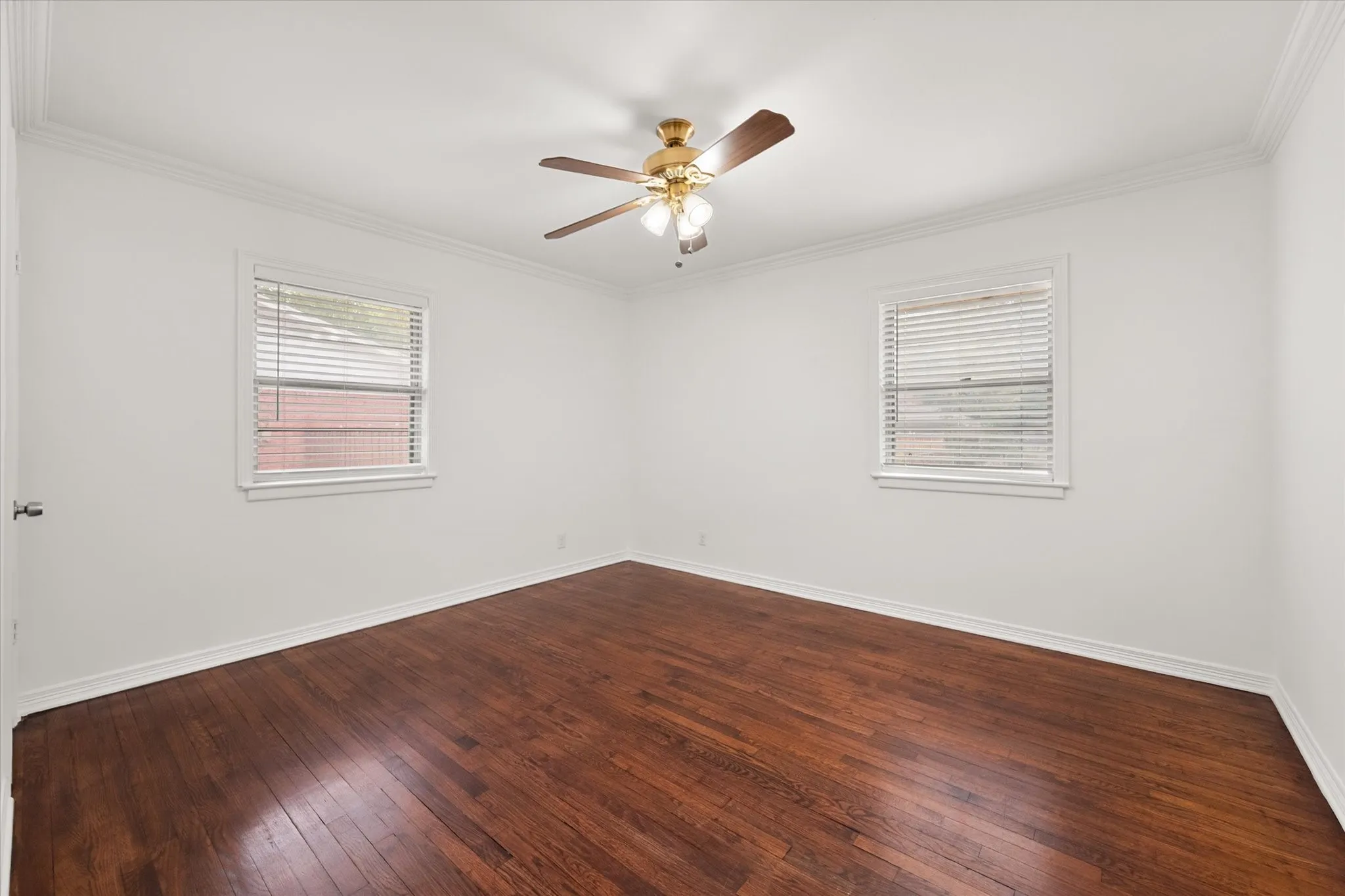 Rich wood-finish flooring, crisp white walls, and elegant crown molding