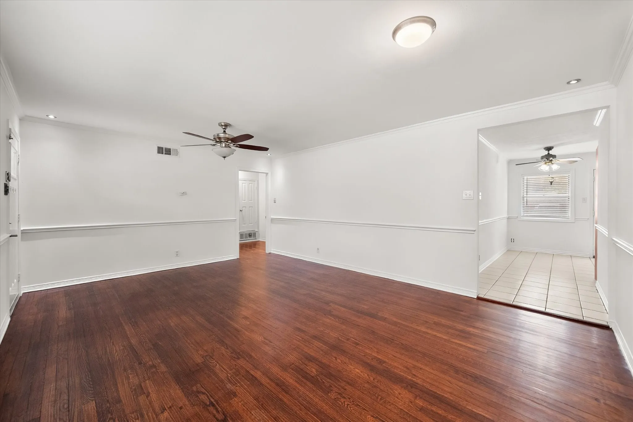 Wood-finish flooring with crisp white walls and crown molding