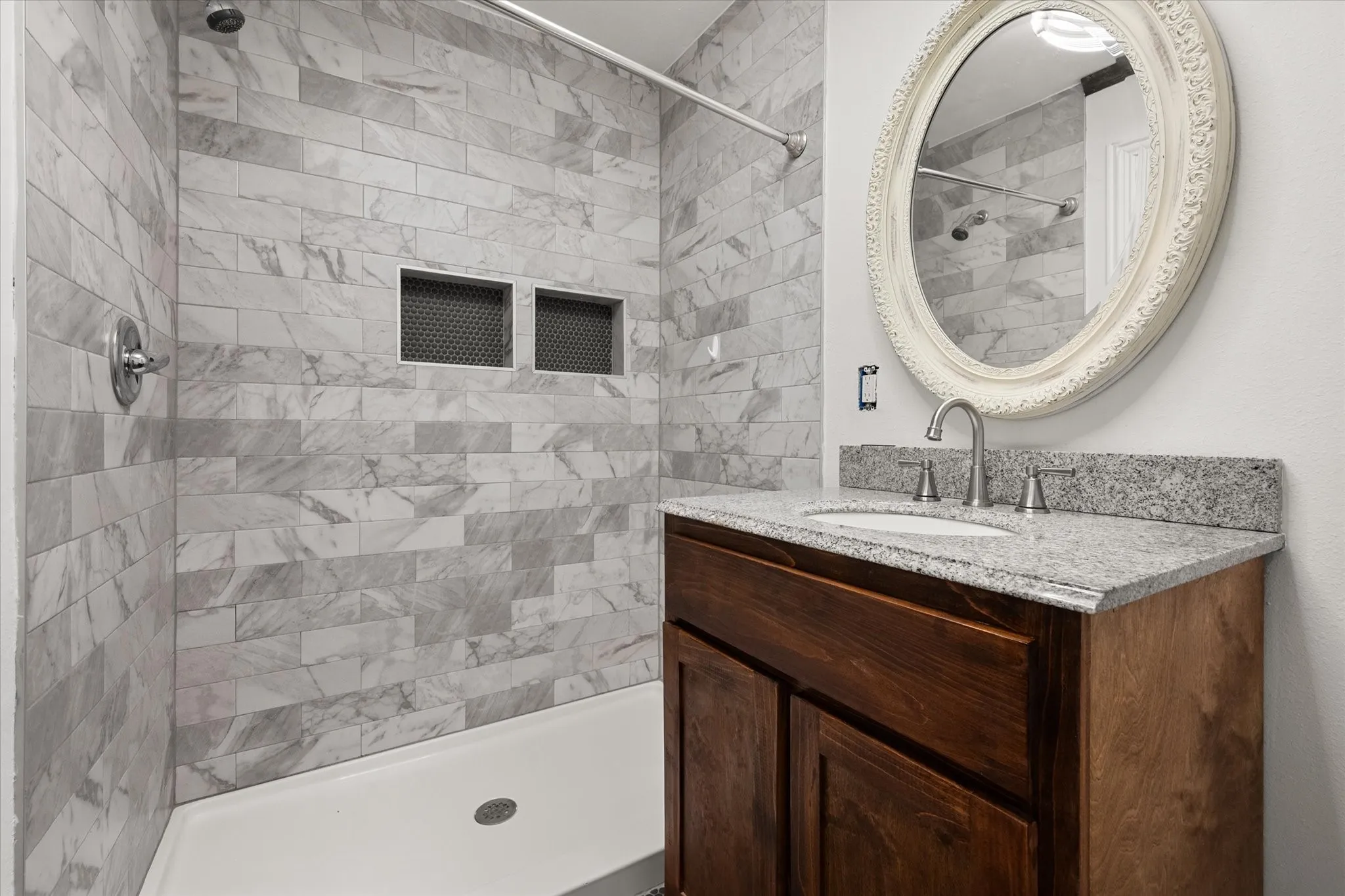 Shower with subway tile surround, integrated shower niches, and a white shower pan
