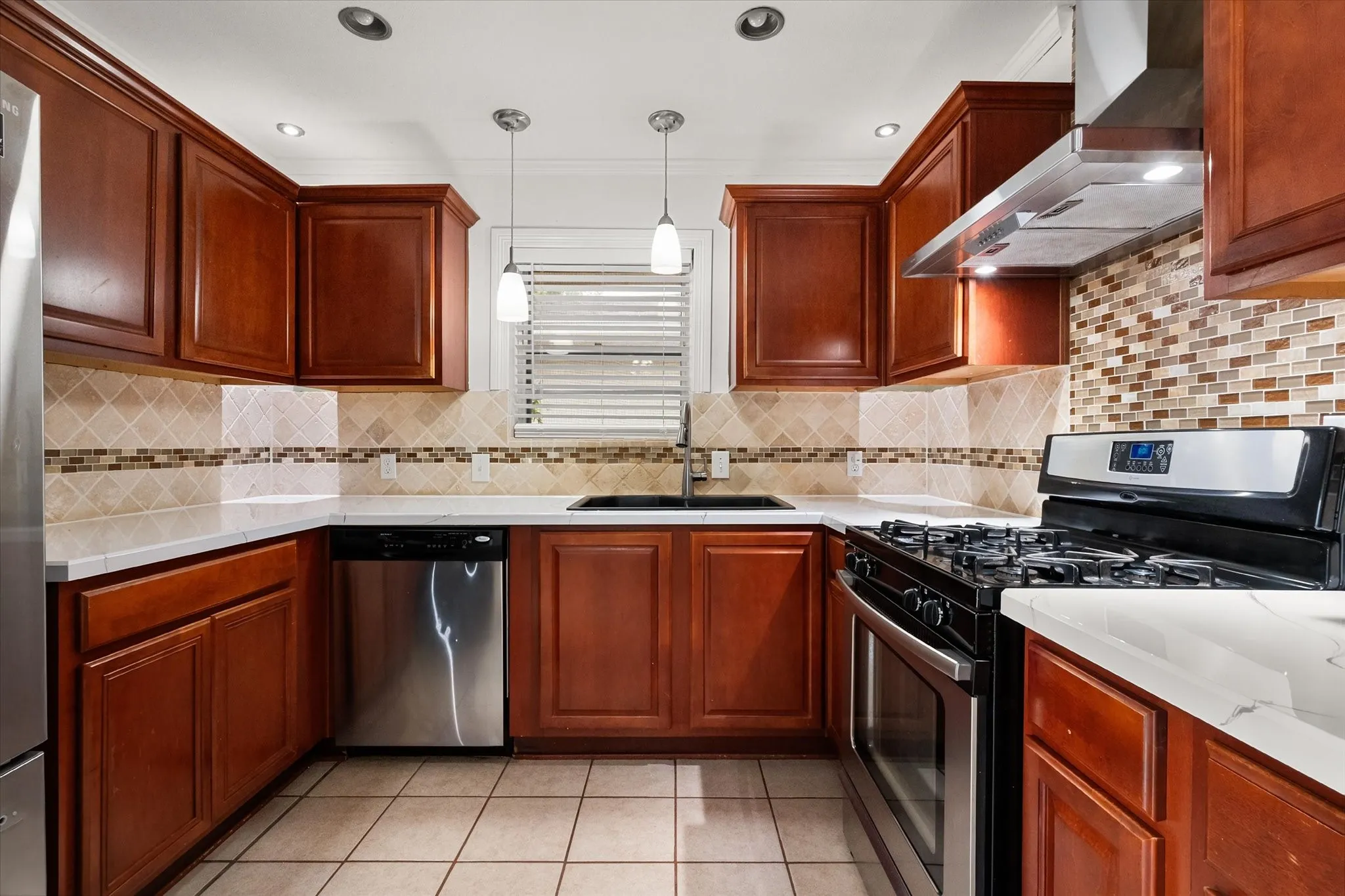 Kitchen featuring wood cabinetry, white countertops, tile flooring, and a mosaic tile backsplash