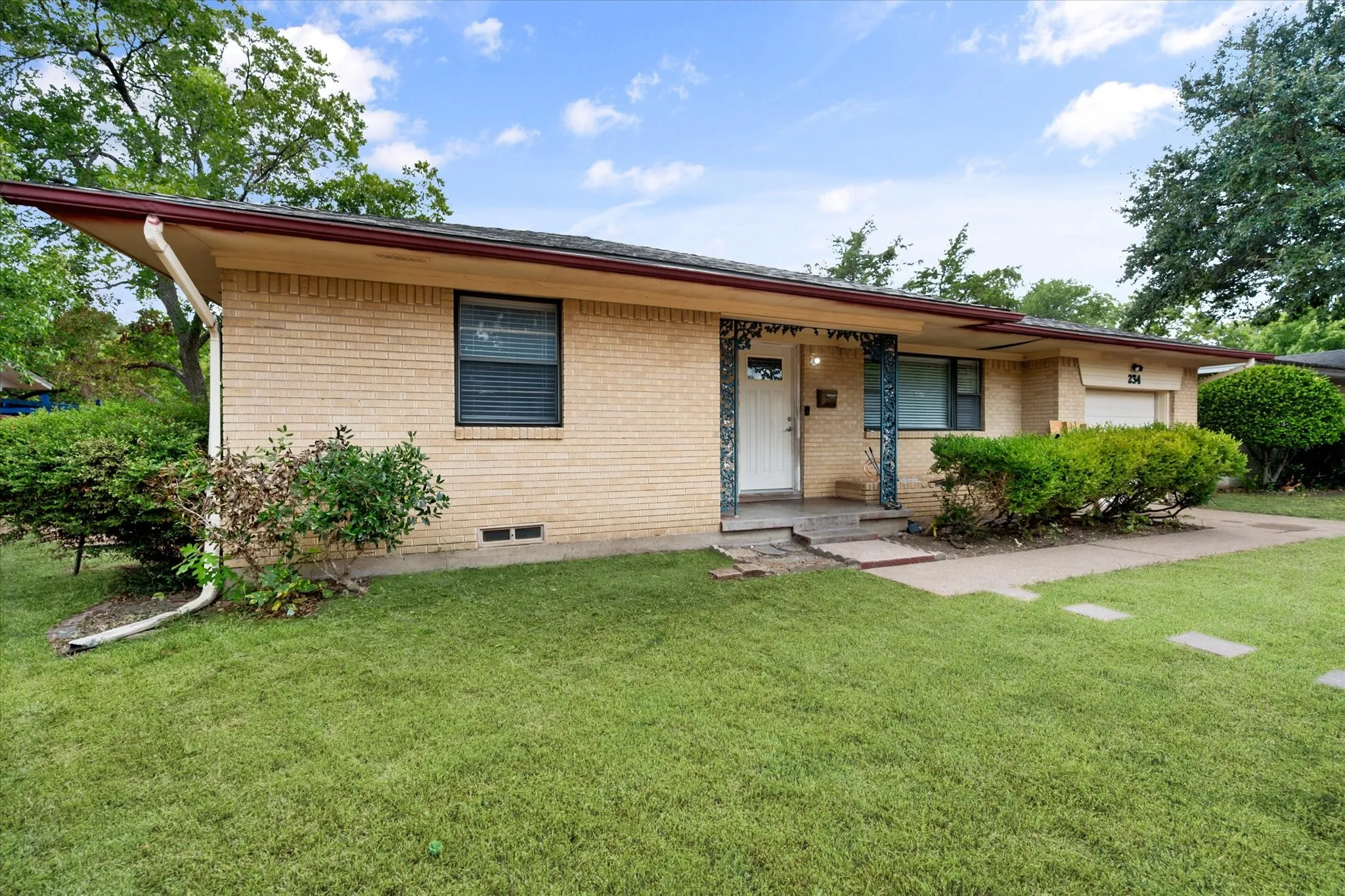 Brick exterior with a covered entry and decorative porch columns