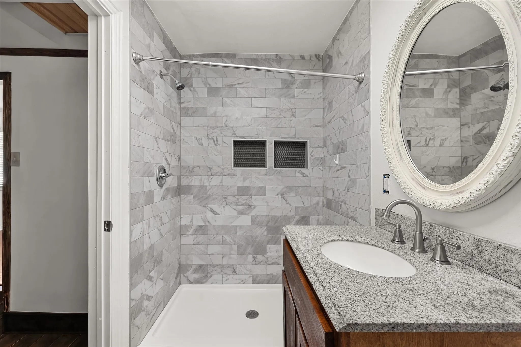Shower with subway tile surround, dual recessed niches, and a white shower pan