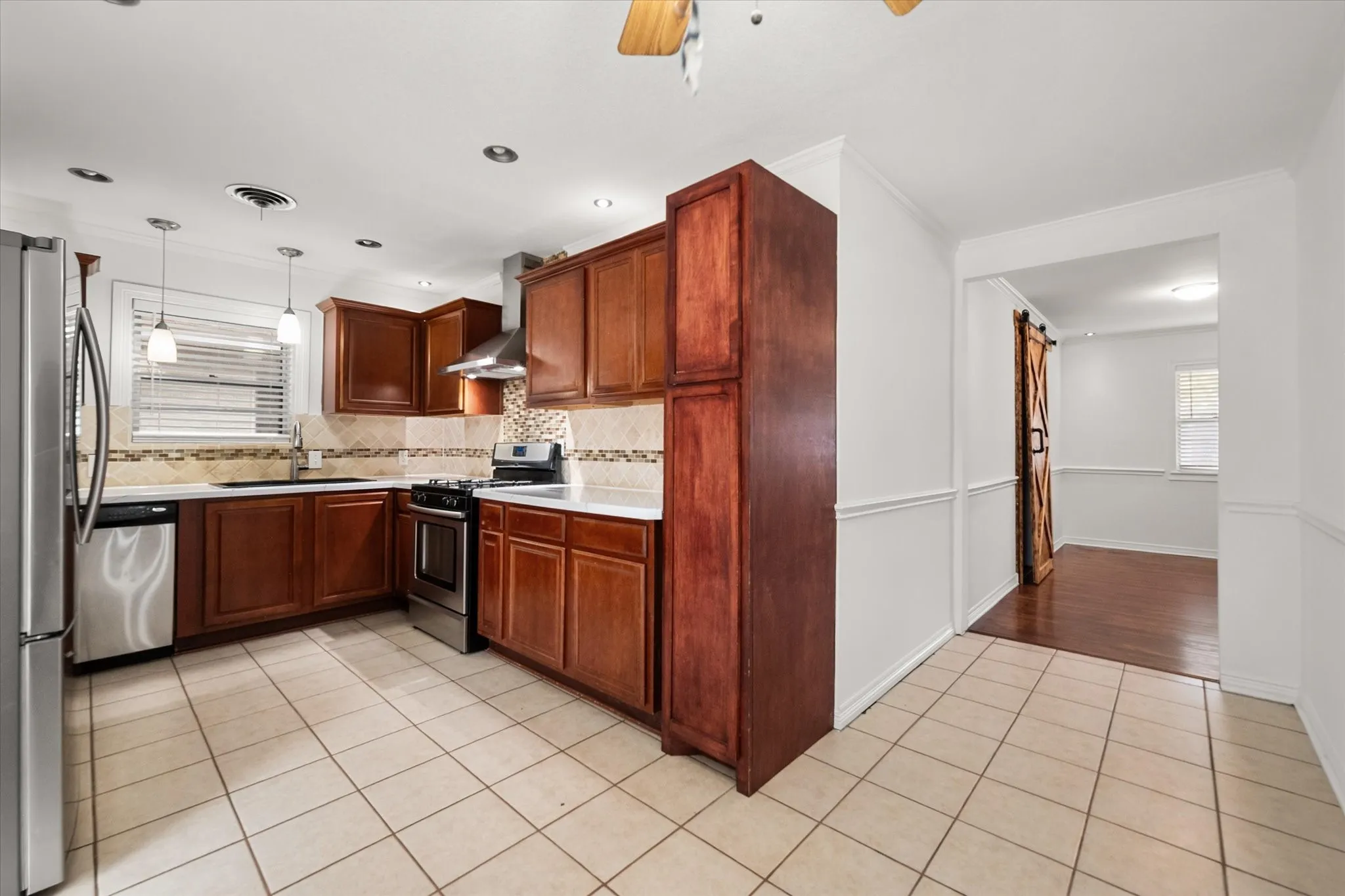 Kitchen featuring wood cabinetry, stainless steel appliances, recessed lighting, and tile flooring