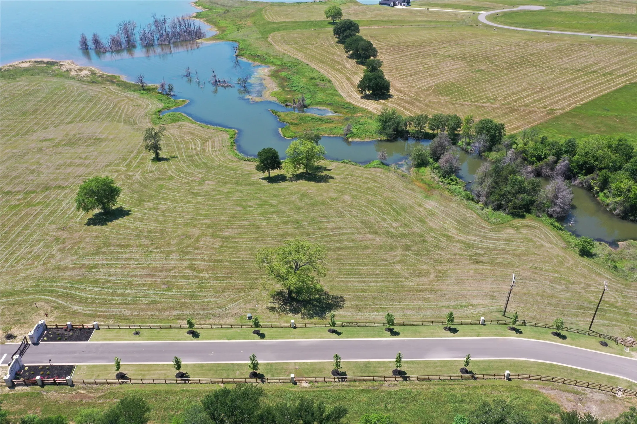 Paved entrance and aerial view of lot running parallel with Shores Dr.