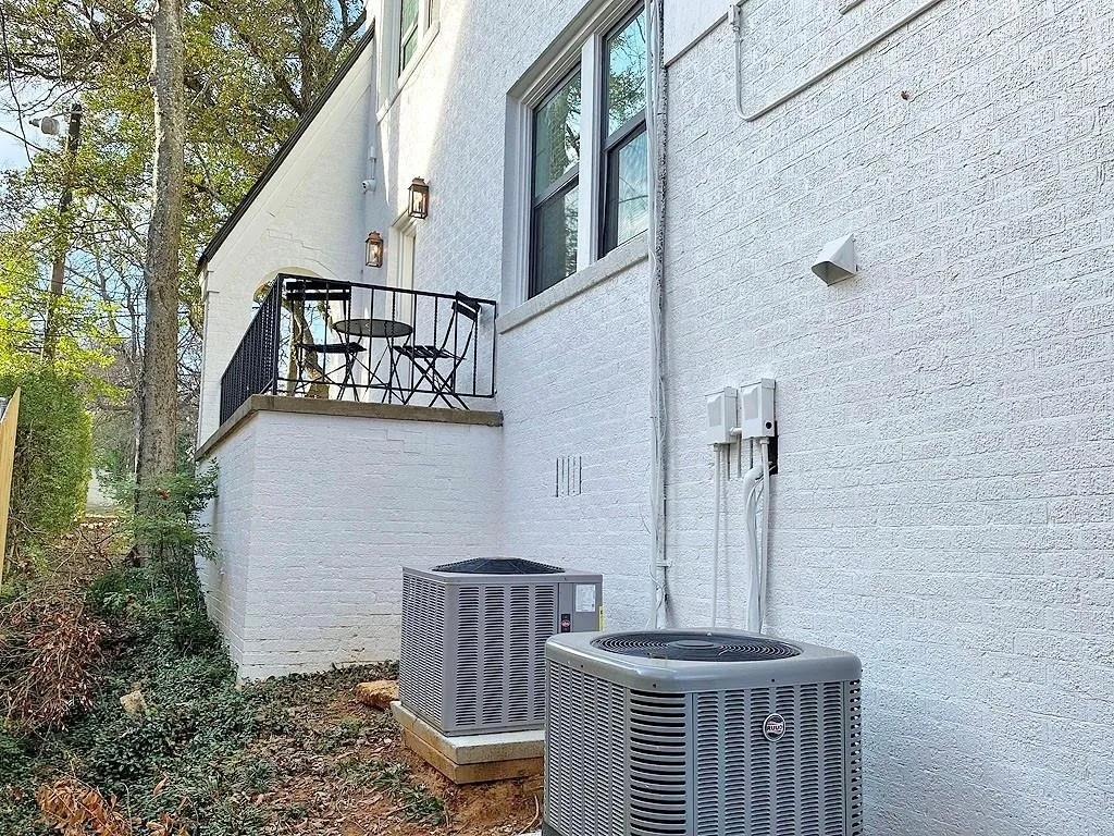 White painted brick exterior with black iron balcony railing