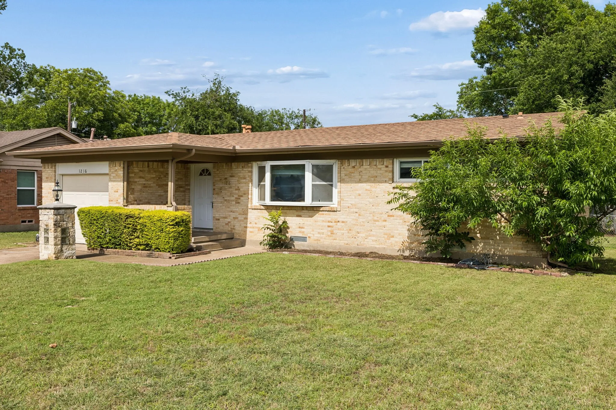 Brick exterior with a covered entry and a single-car garage