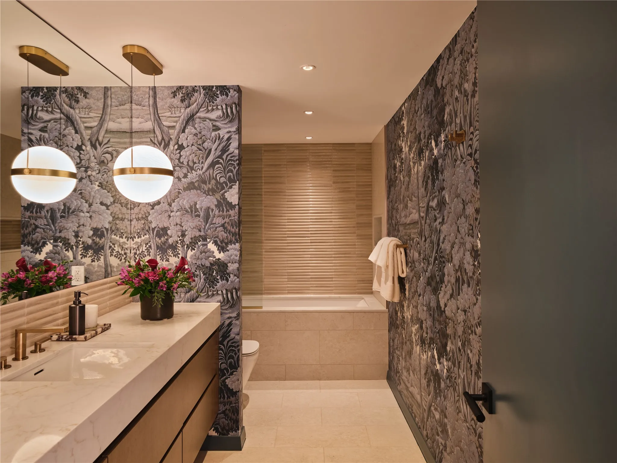 Guest bath with House of Hackney wallpaper and brushed bronze Kohler fixtures
