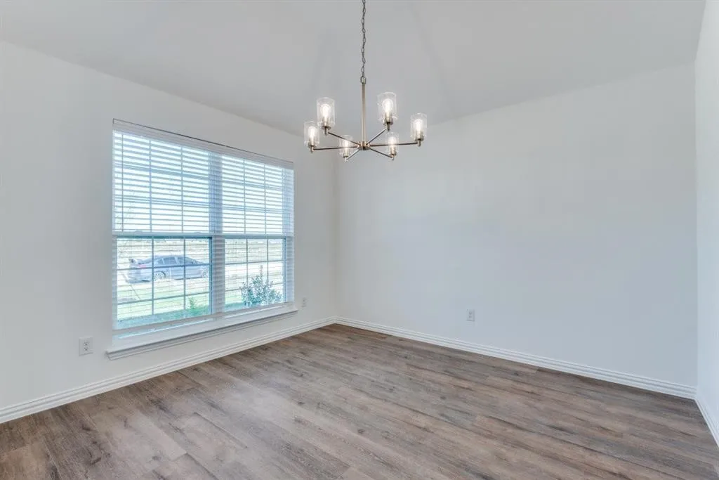 Wood-finish flooring, white walls, and a contemporary chandelier