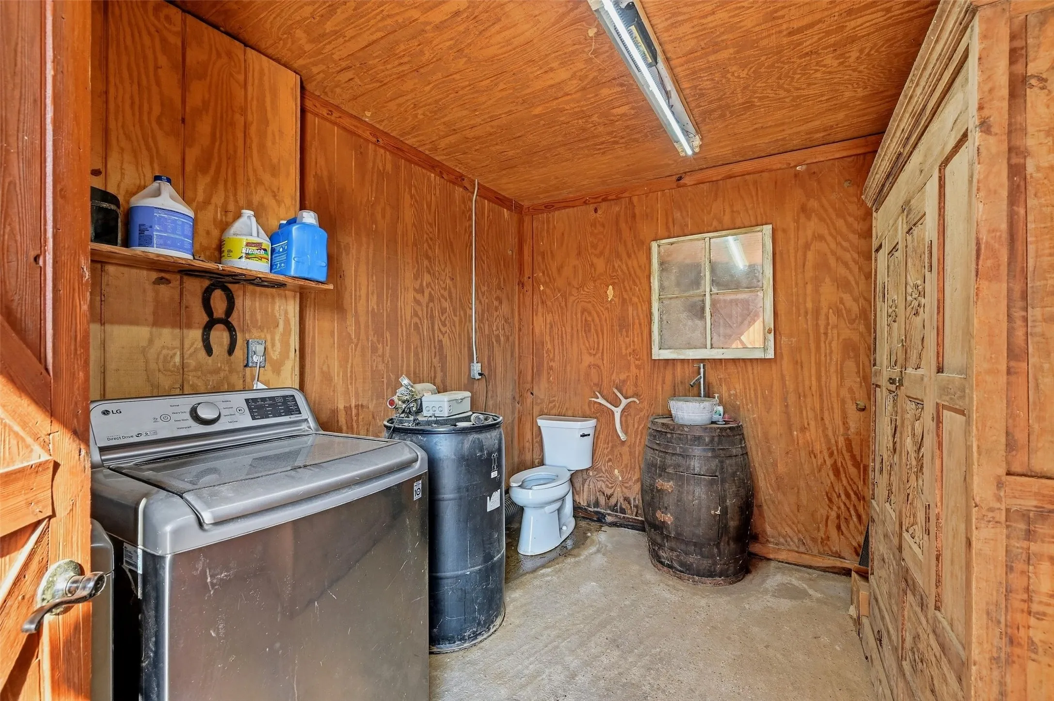 Laundry room with toilet and sink.