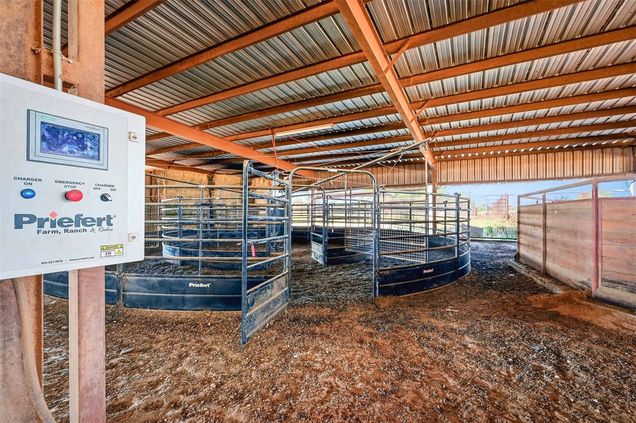 Covered Priefert panel  horse walker adjacent to round pen.