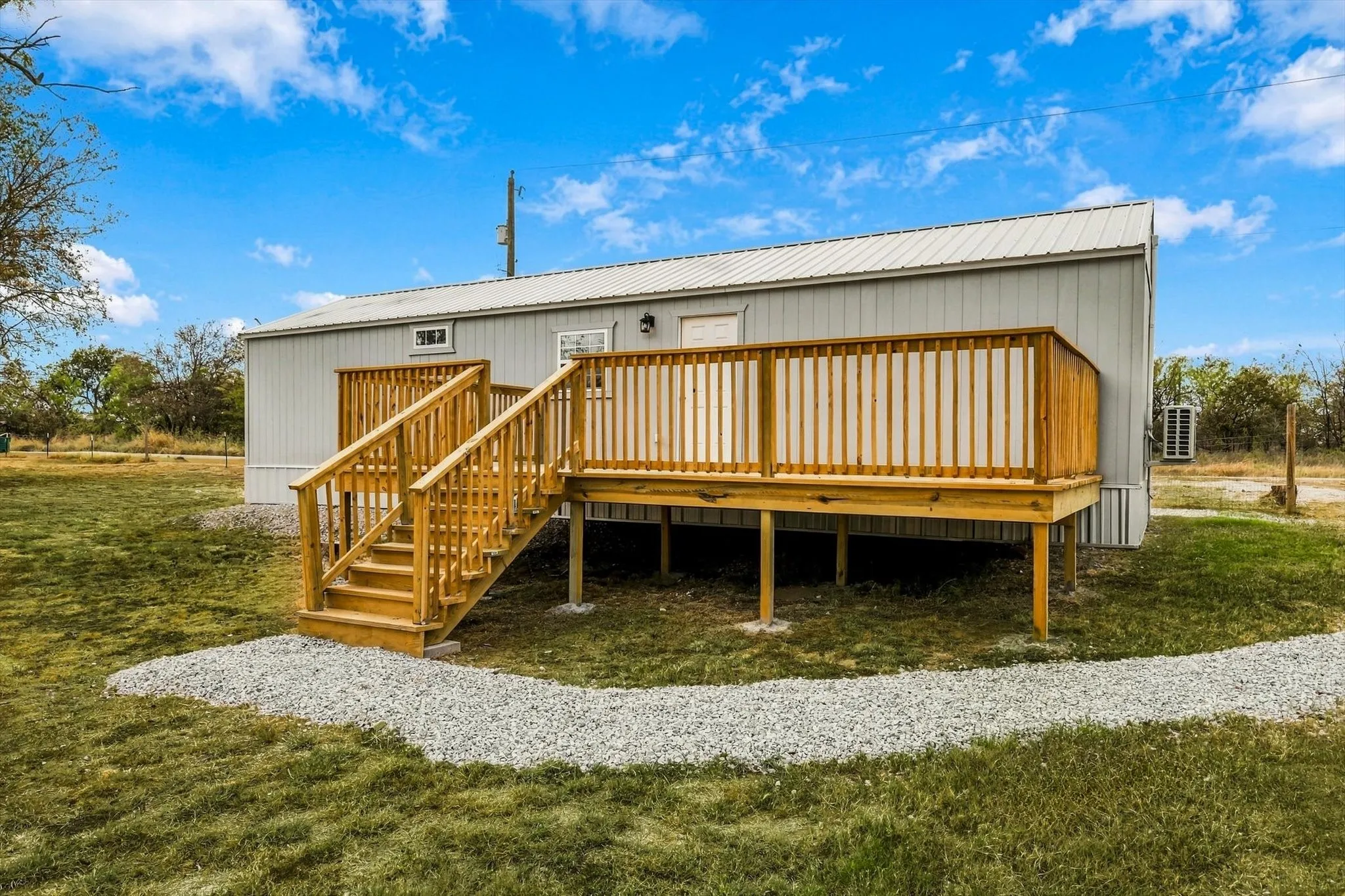 Expansive wooden deck with coordinating railings, stairs, and gray vinyl siding