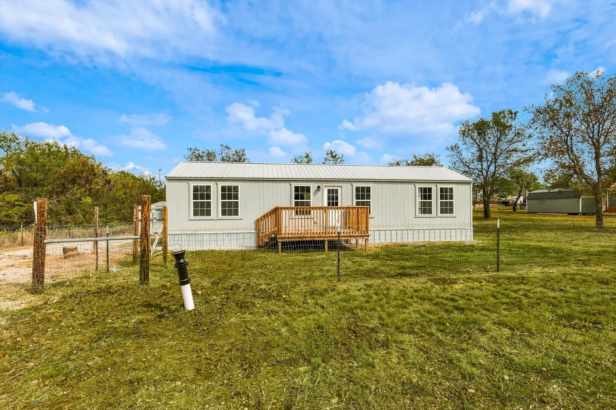 Light-colored siding exterior with a white metal roof
