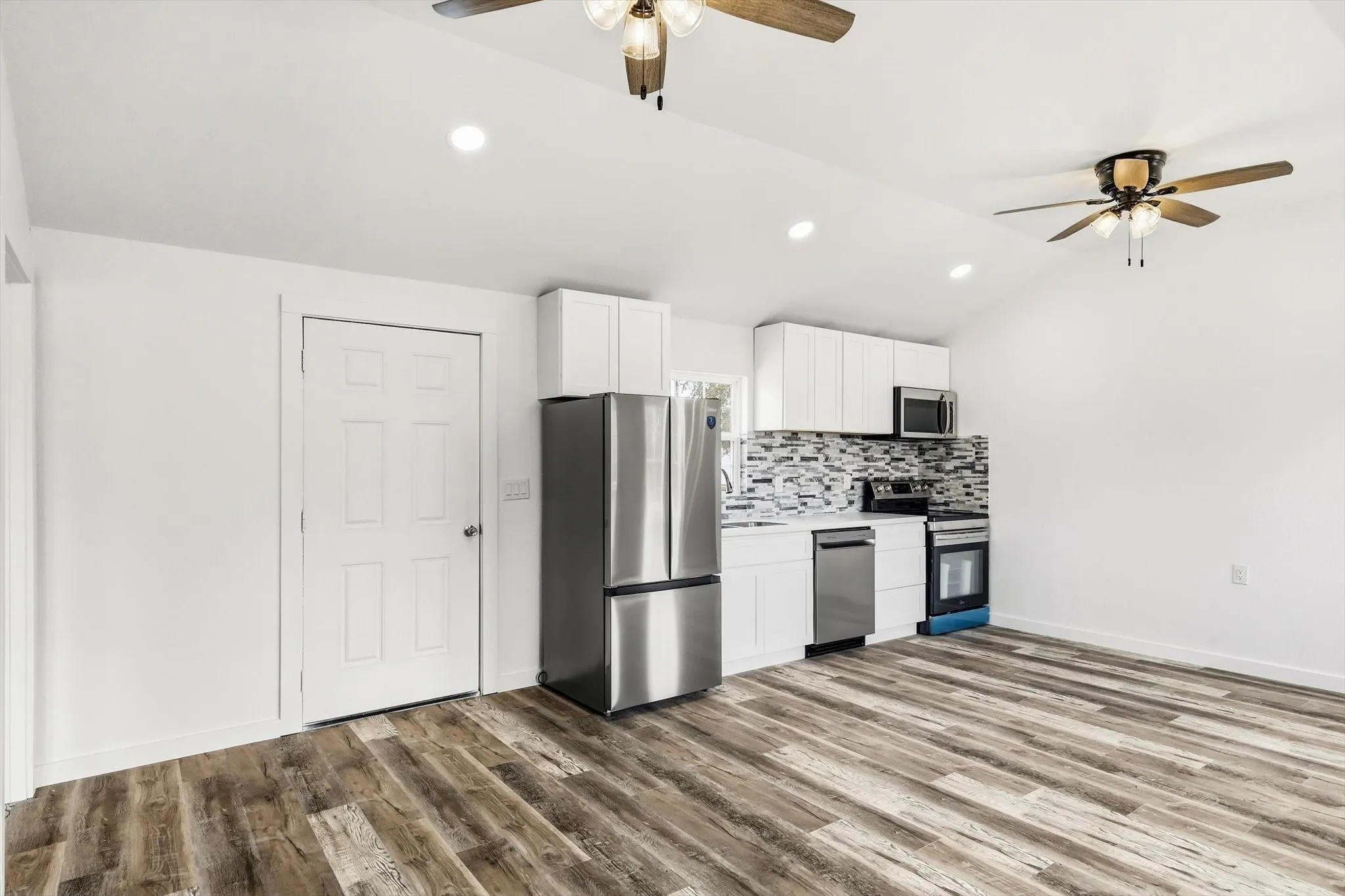 Vaulted ceiling with recessed lighting and ceiling fans