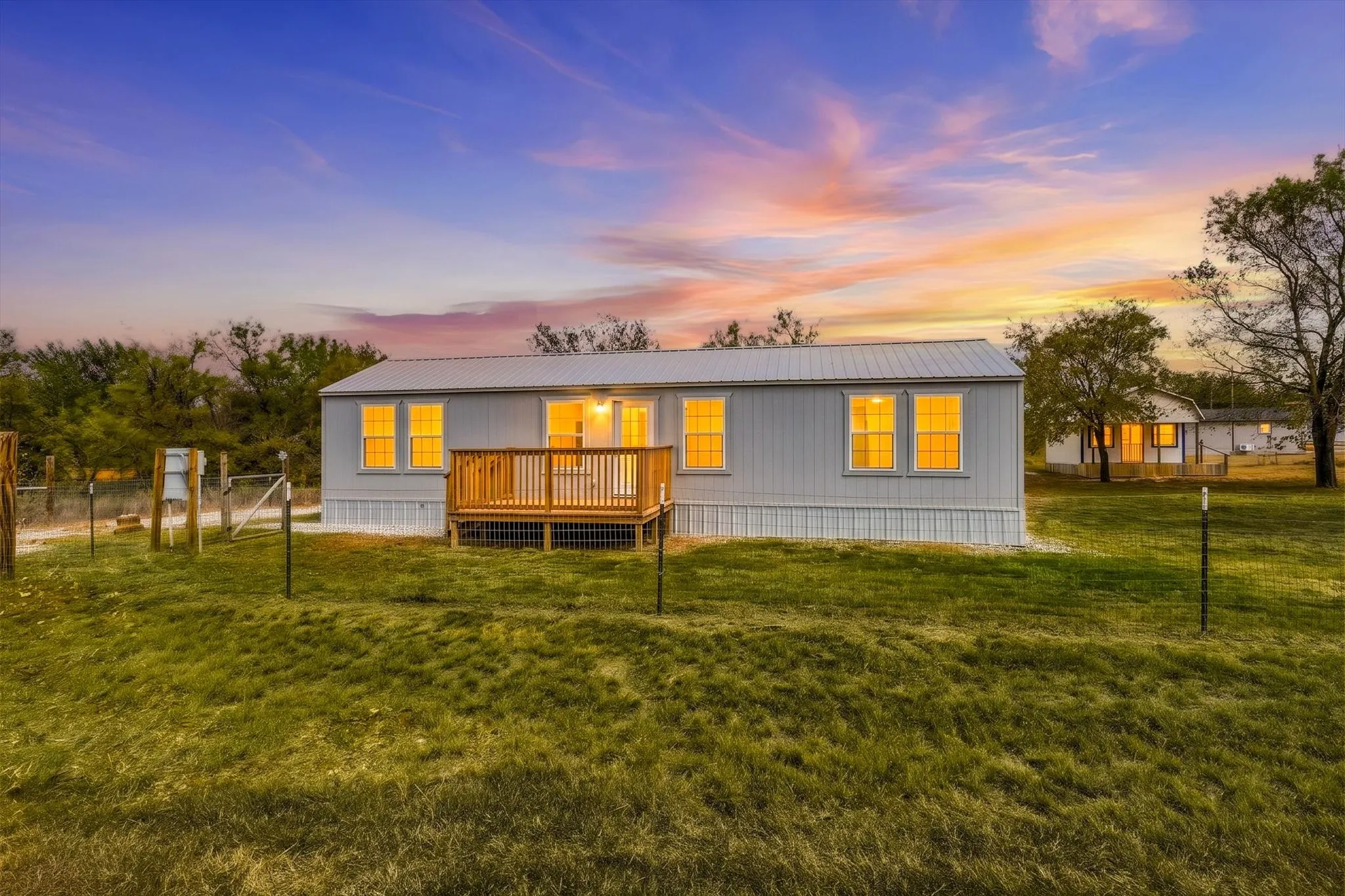 Virtual Twilight sky light gray siding exterior with a metal roof