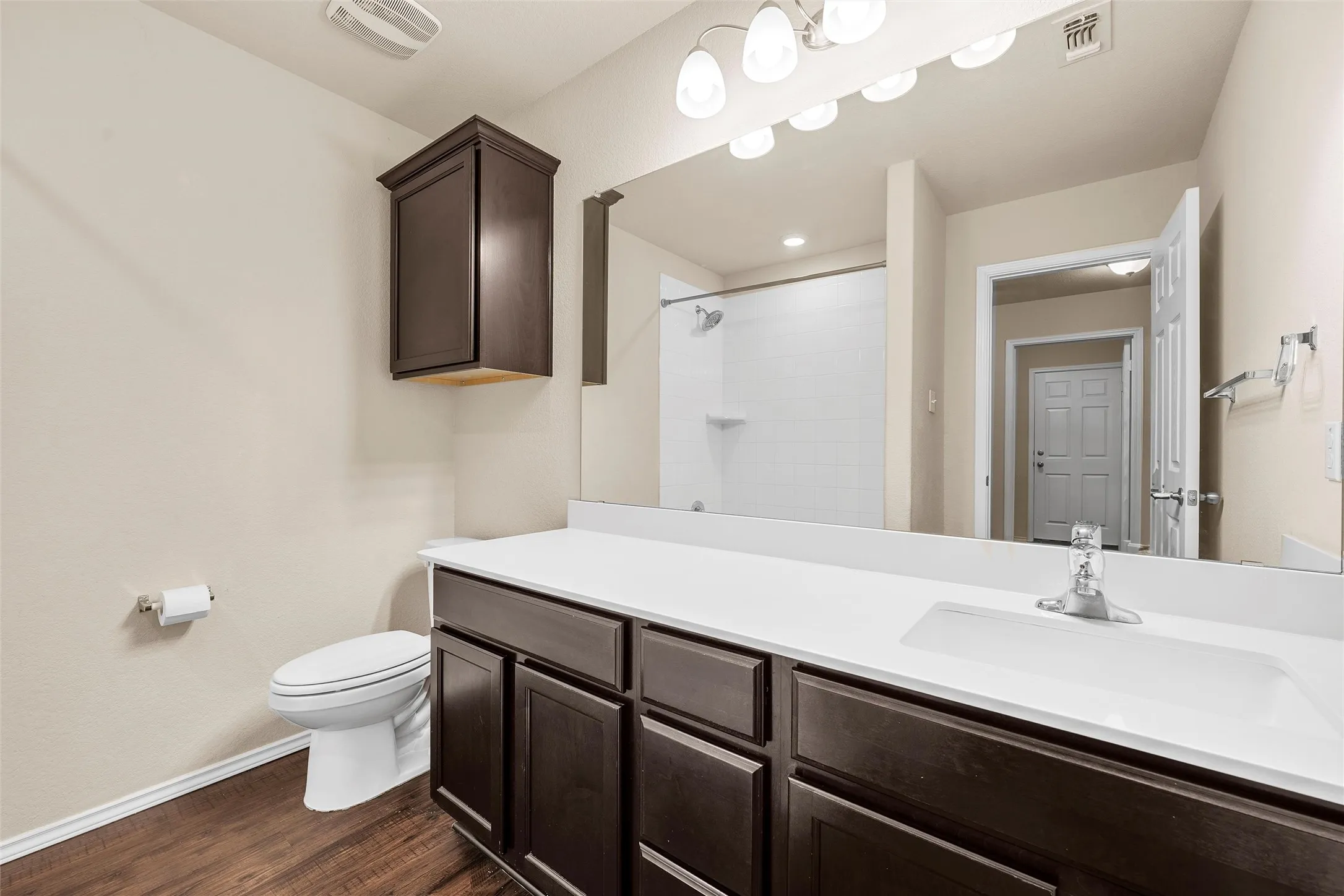 Bathroom with vanity, tiled shower, and wood finished floors