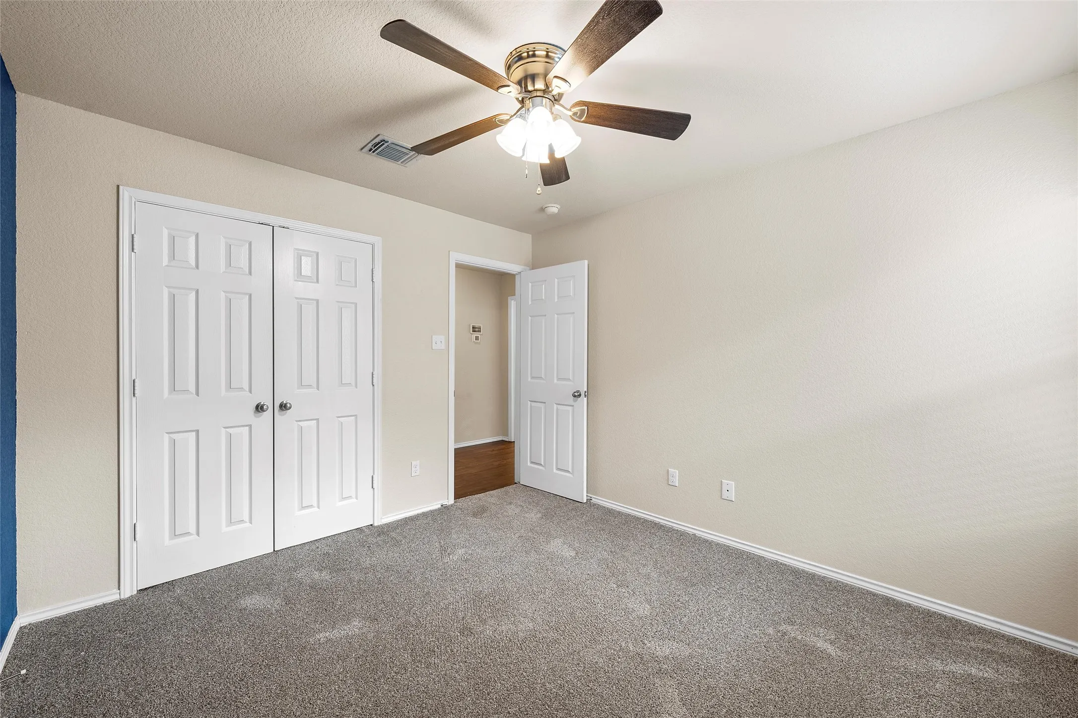 Unfurnished bedroom with carpet flooring, a closet, and ceiling fan