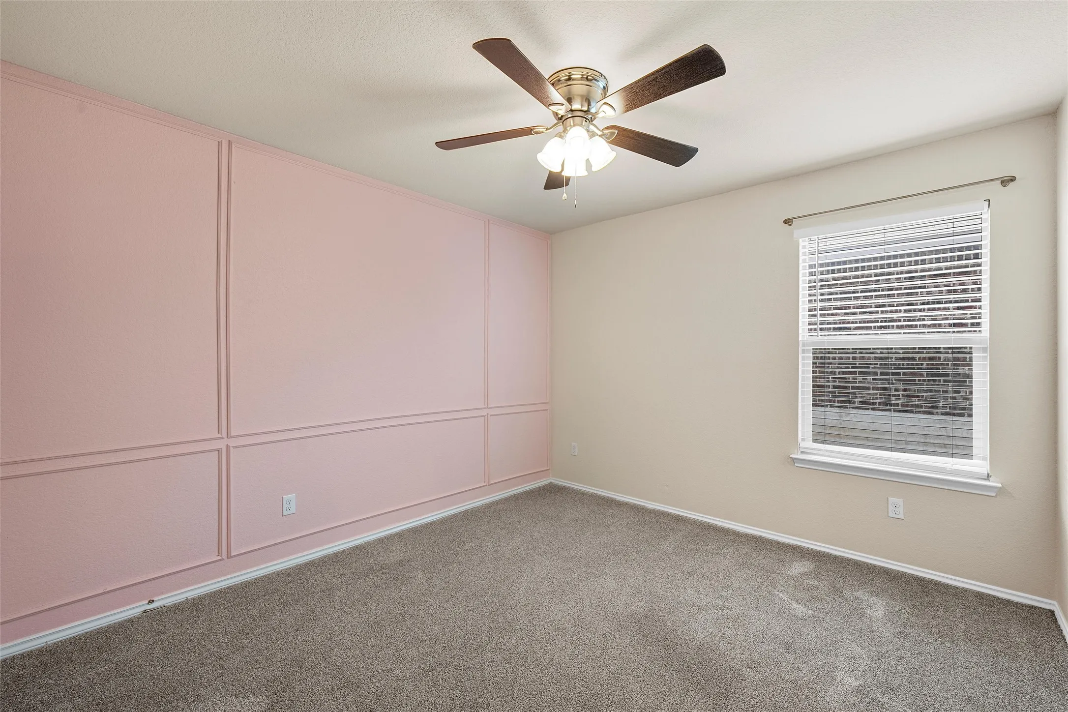 Carpeted empty room with ceiling fan and baseboards