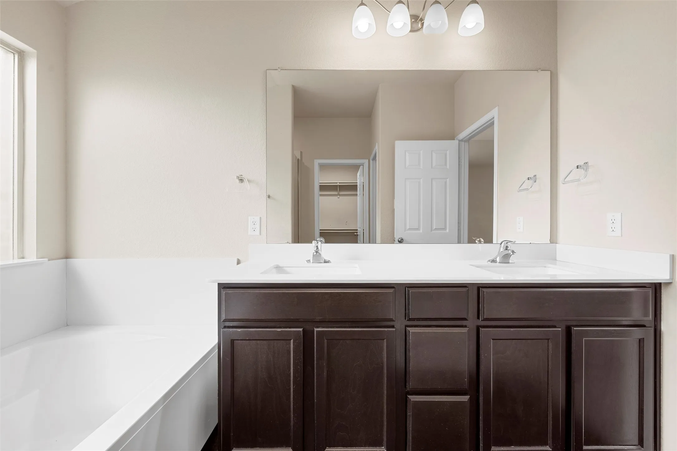 Full bathroom featuring double vanity and a bath