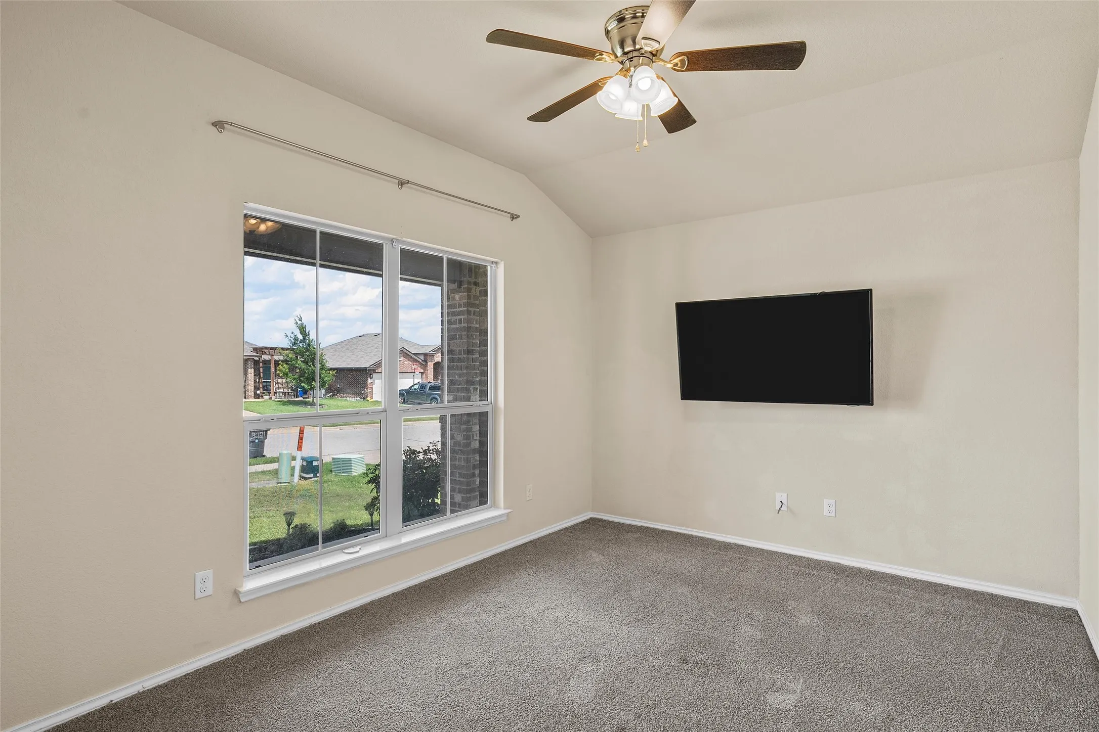 Unfurnished room with vaulted ceiling, carpet floors, and ceiling fan