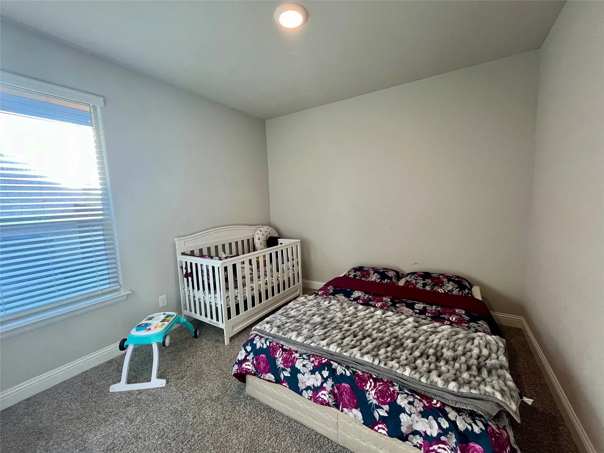Recessed lighting, window with blinds, light-toned walls, and carpet flooring