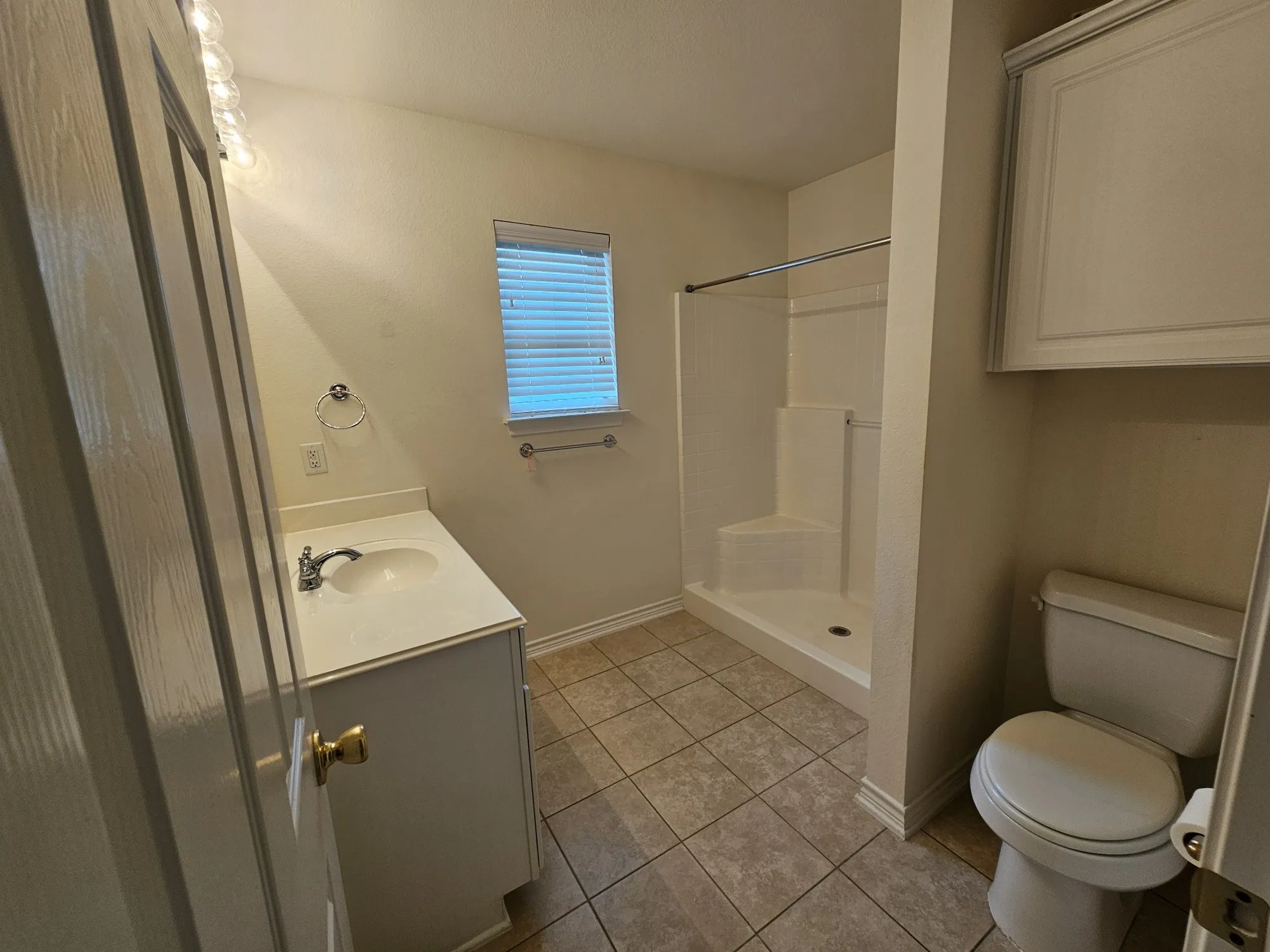 Spacious garage with polished concrete flooring, wall-mounted storage cabinetry, overhead lighting, and an automatic garage door opener